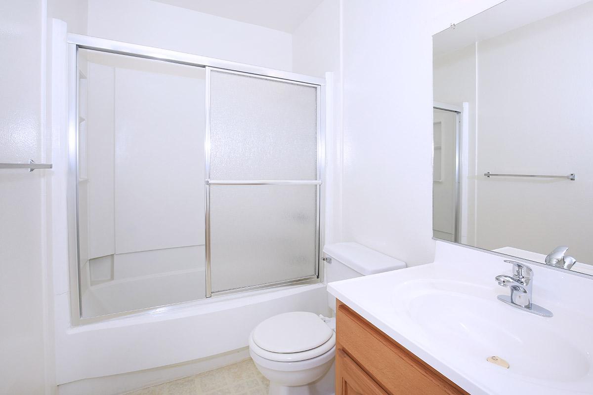 a white sink sitting next to a shower