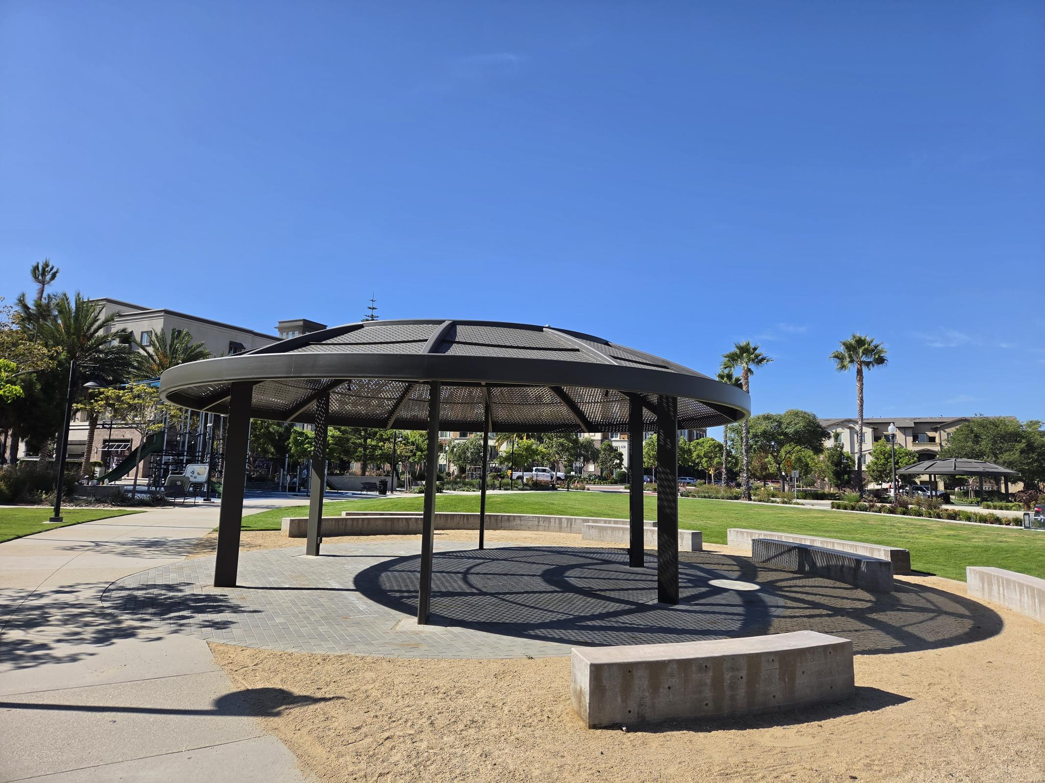 Discover your perfect retreat in our vibrant community, where inviting outdoor spaces like this beautiful gazebo invite relaxation and socialization under a sunlit sky.