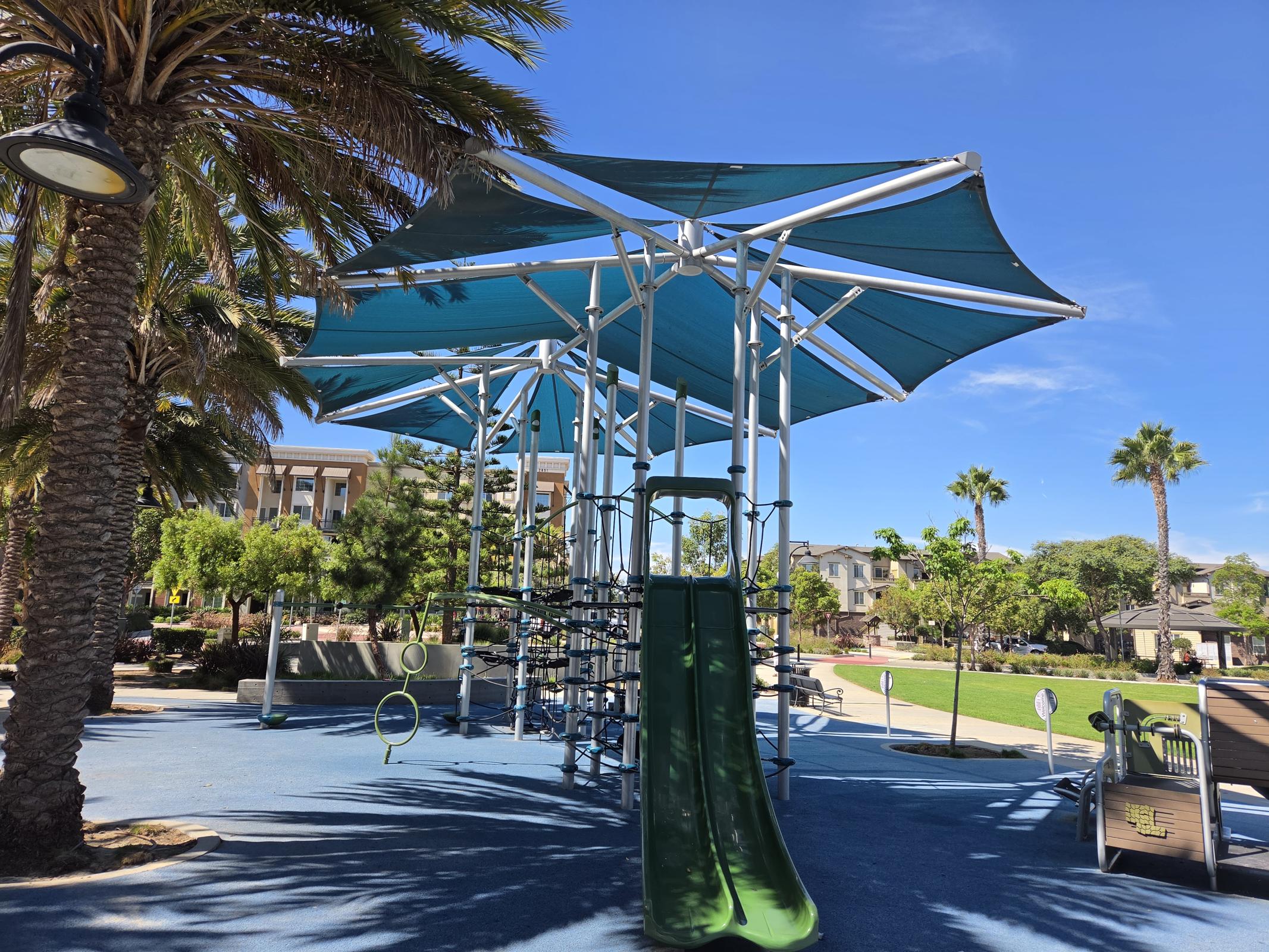 Discover a vibrant community where adventure awaits for all ages at our shaded playground, surrounded by lush palm trees and inviting green spaces, perfect for family fun and relaxation.