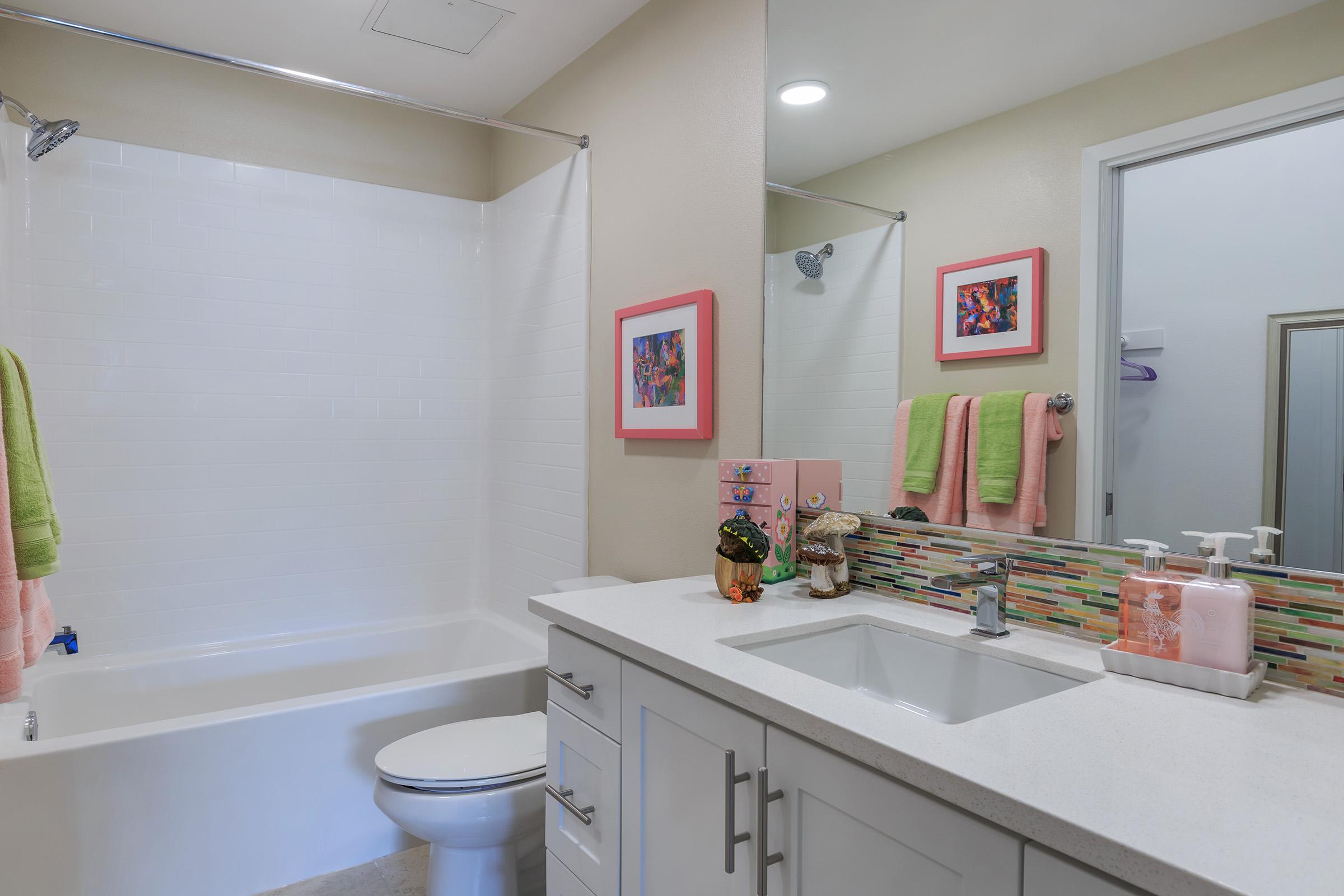 furnished bathroom with white cabinets