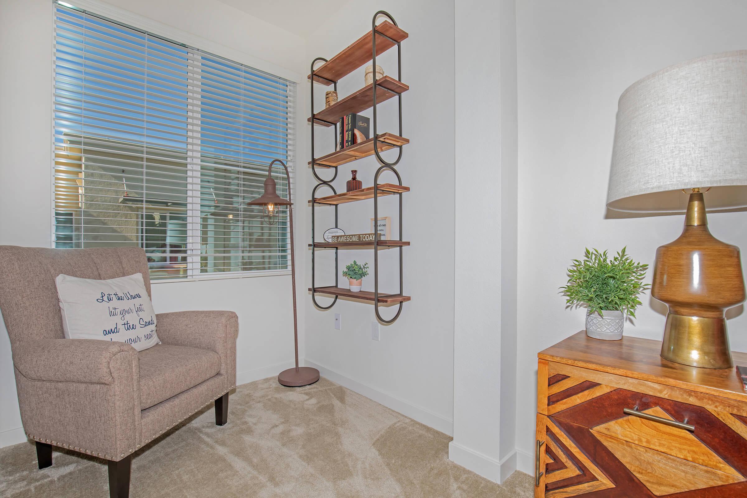 furnished carpeted area with a tan chair