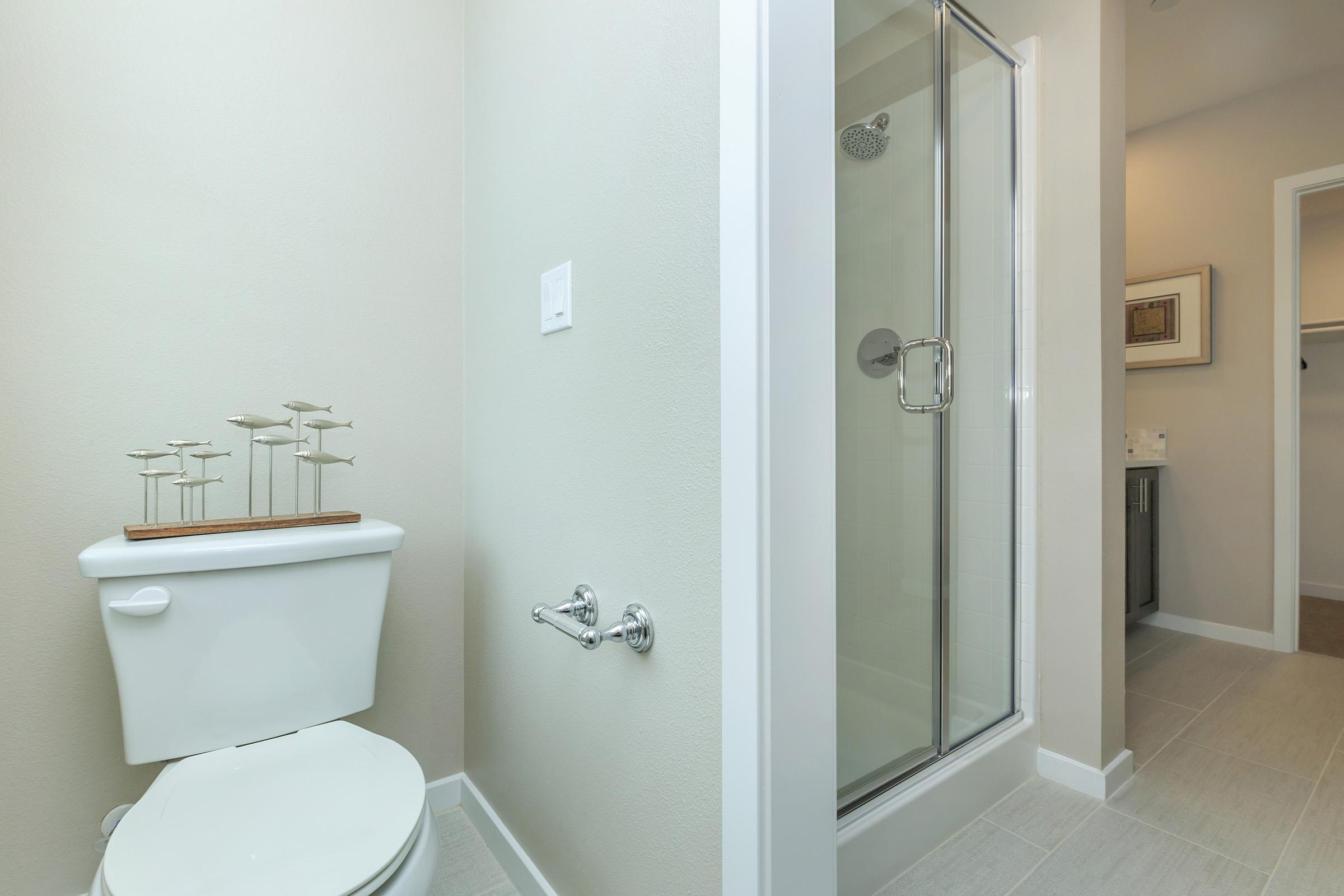 bathroom with tile flooring and a glass shower door