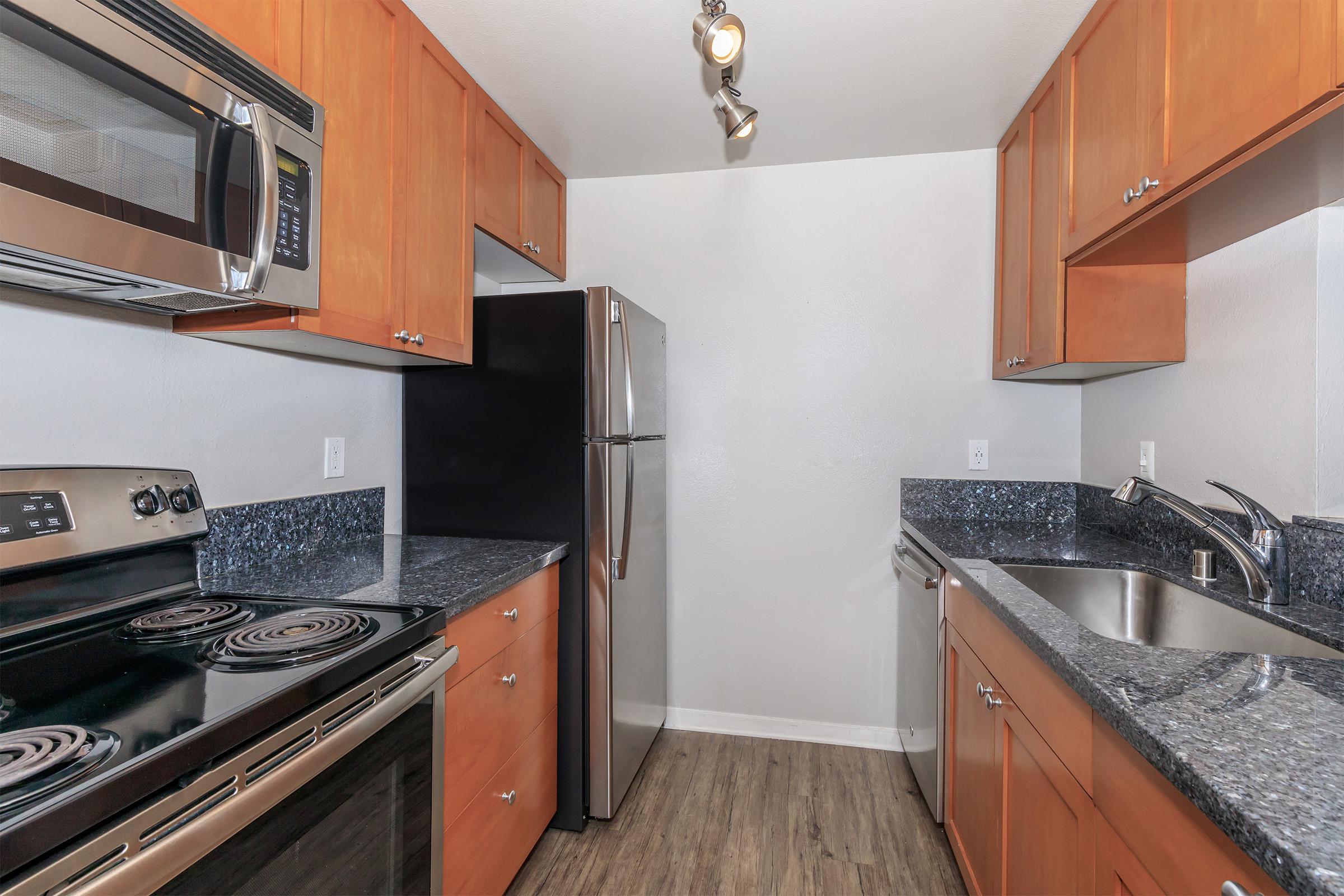 a kitchen with stainless steel appliances and wooden cabinets