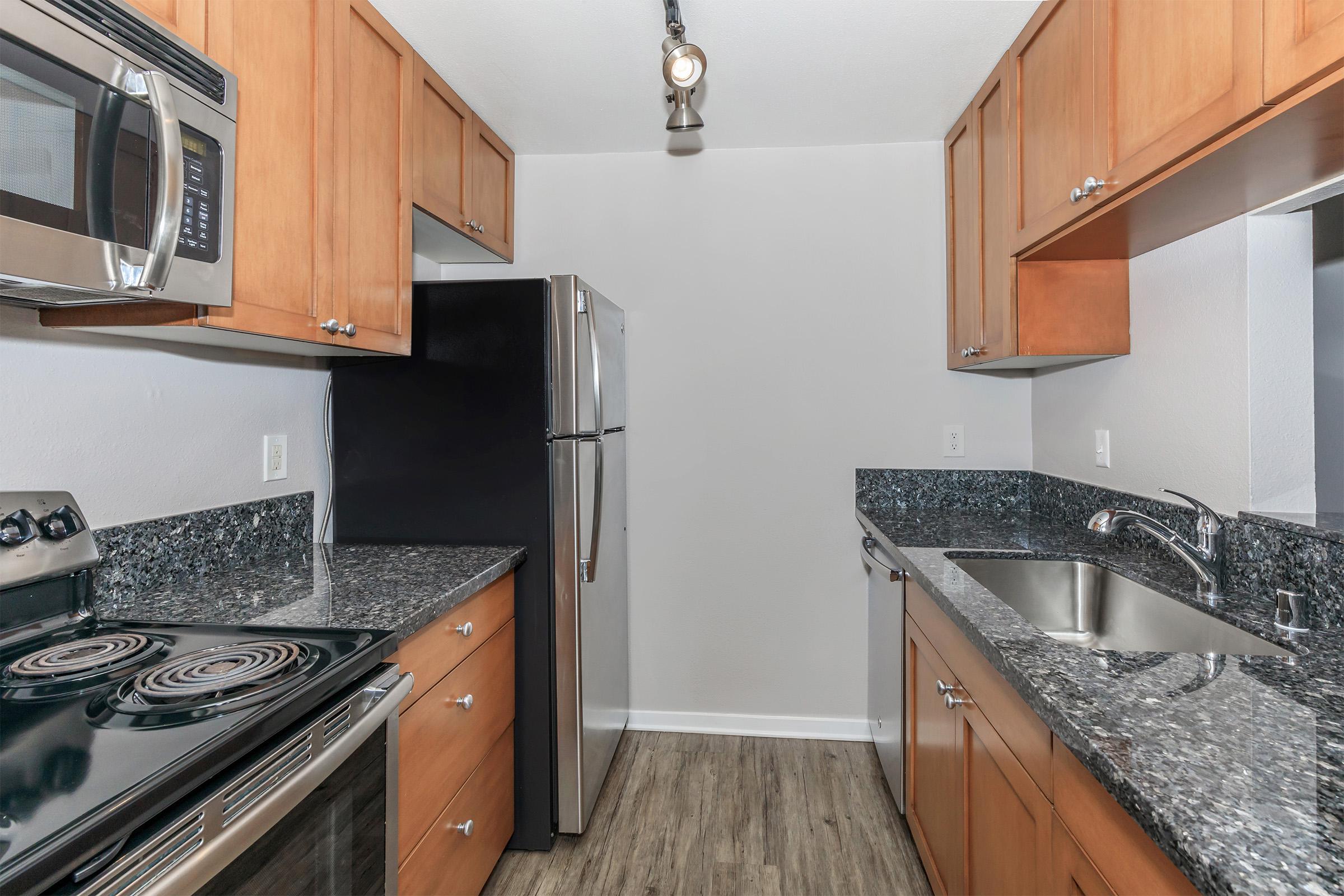 a modern kitchen with stainless steel appliances and wooden cabinets