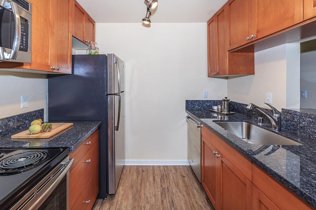 a modern kitchen with stainless steel appliances and wooden cabinets