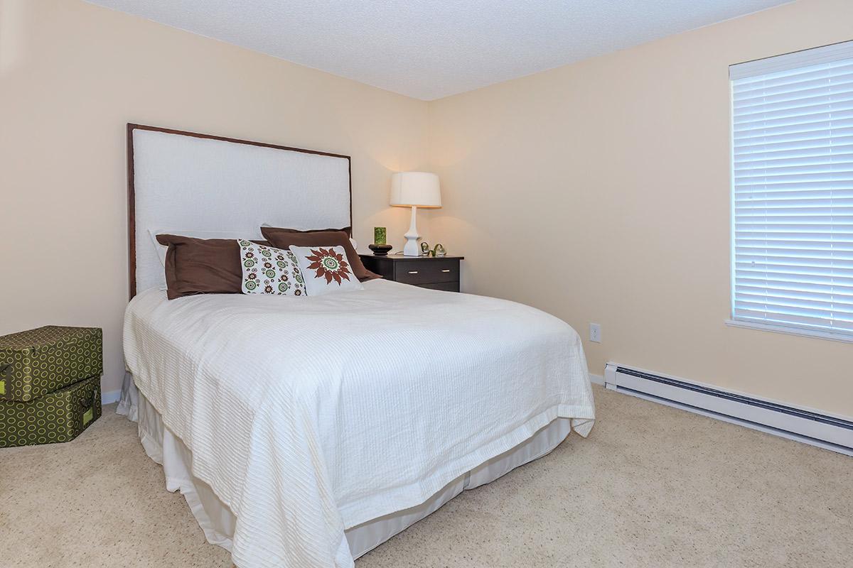 a bedroom with a bed and desk in a hotel room