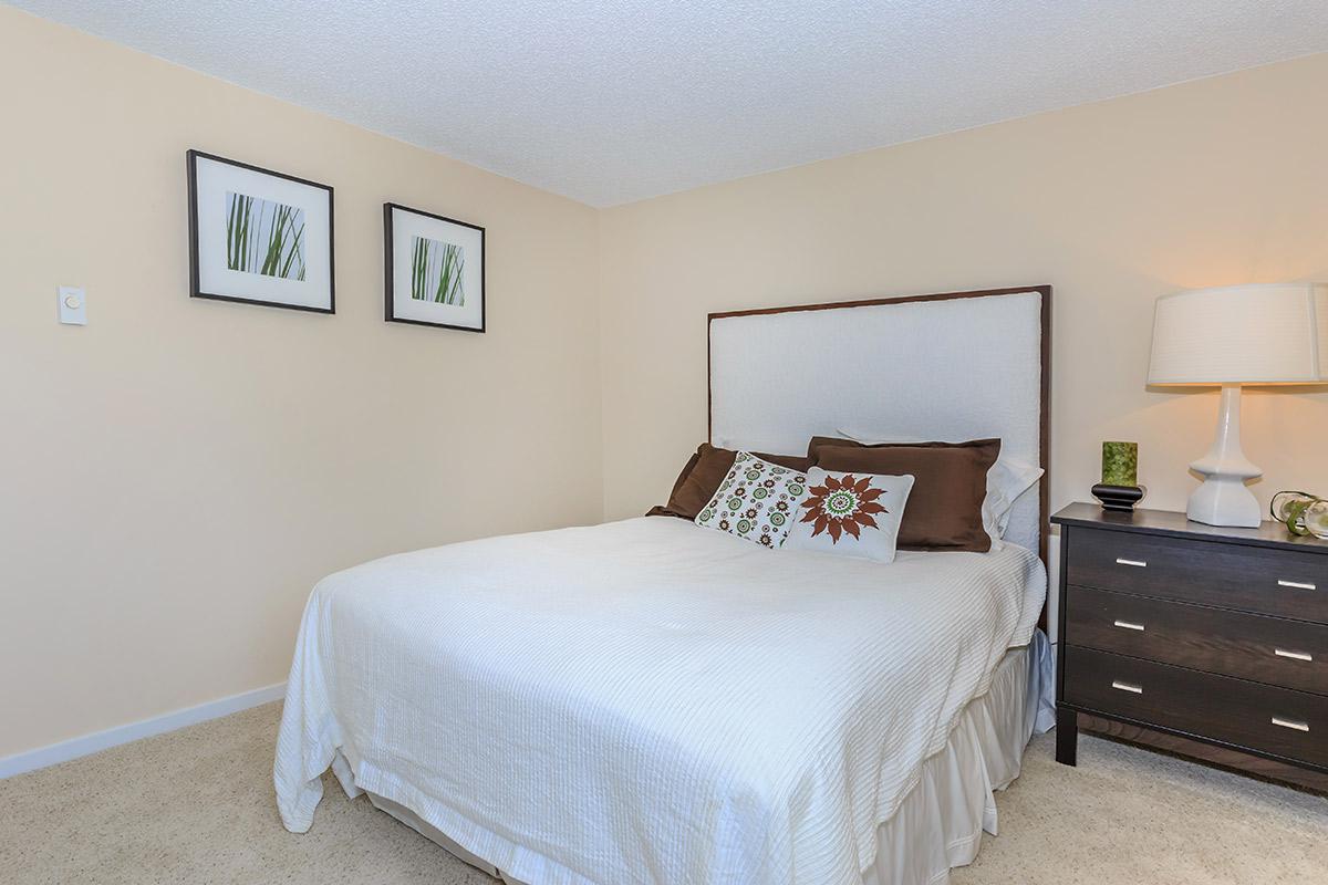 a bedroom with a bed and desk in a hotel room