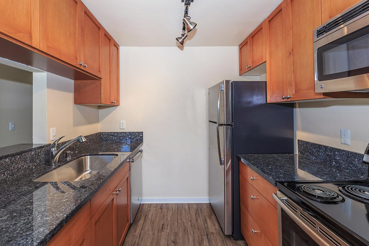 a modern kitchen with stainless steel appliances and wooden cabinets