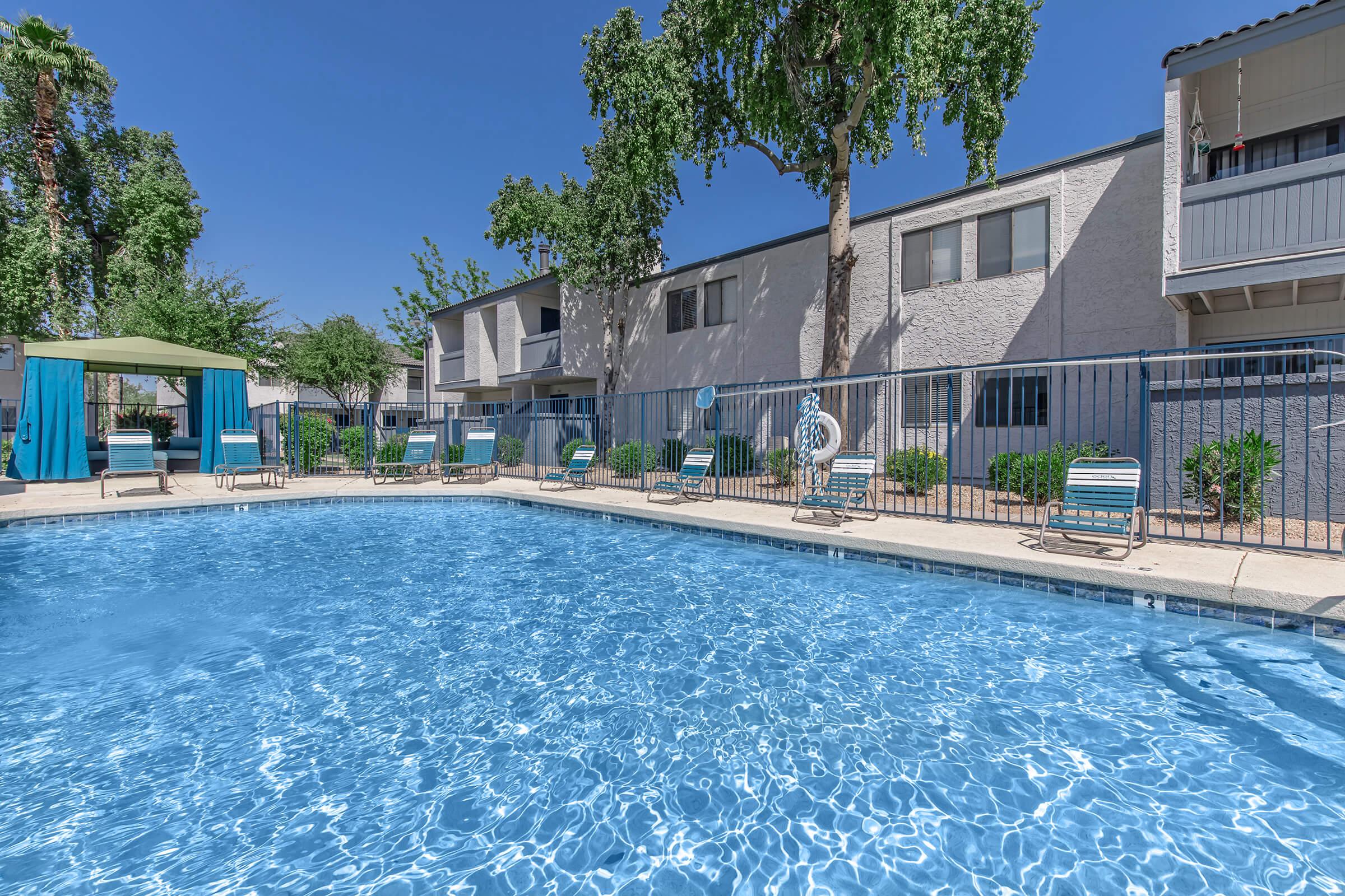 A large dazzling pool surrounded by the apartments at Rise on McClintock.