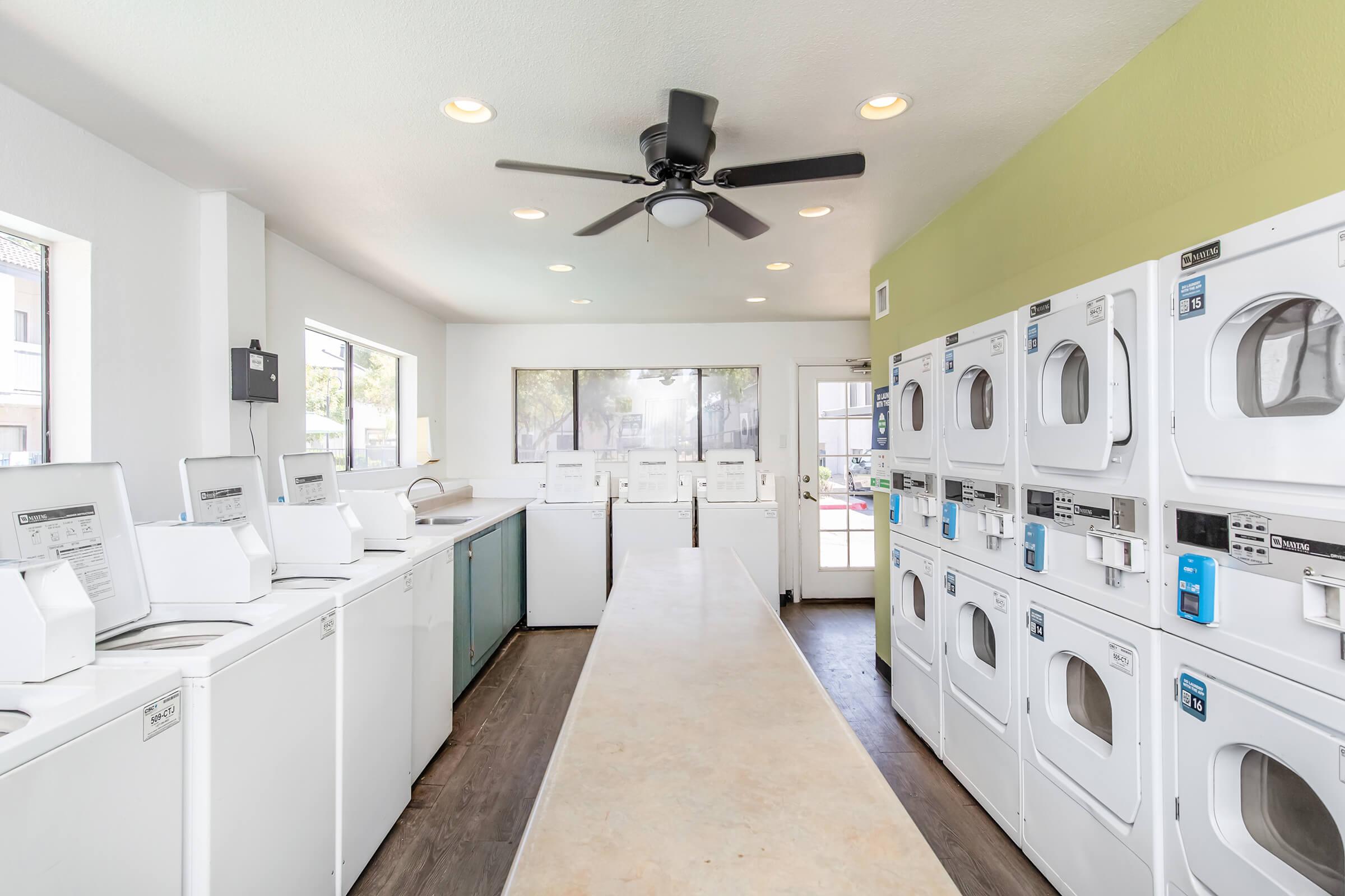 A laundry room with many washers and dryers for the apartments at Rise on MCclintock.