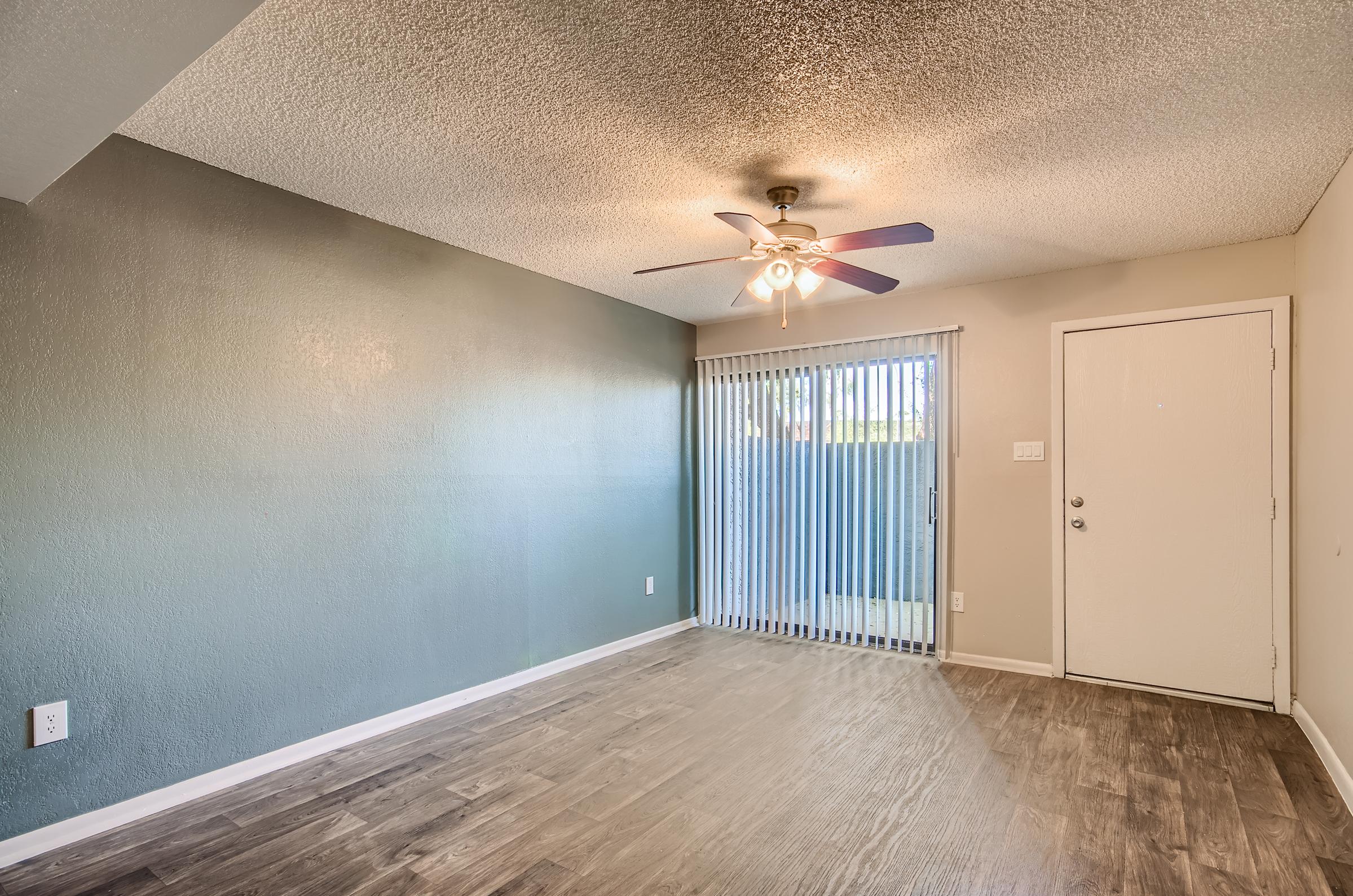 A first floor apartment living room at Rise on McClintock with sliding doors to the balcony.