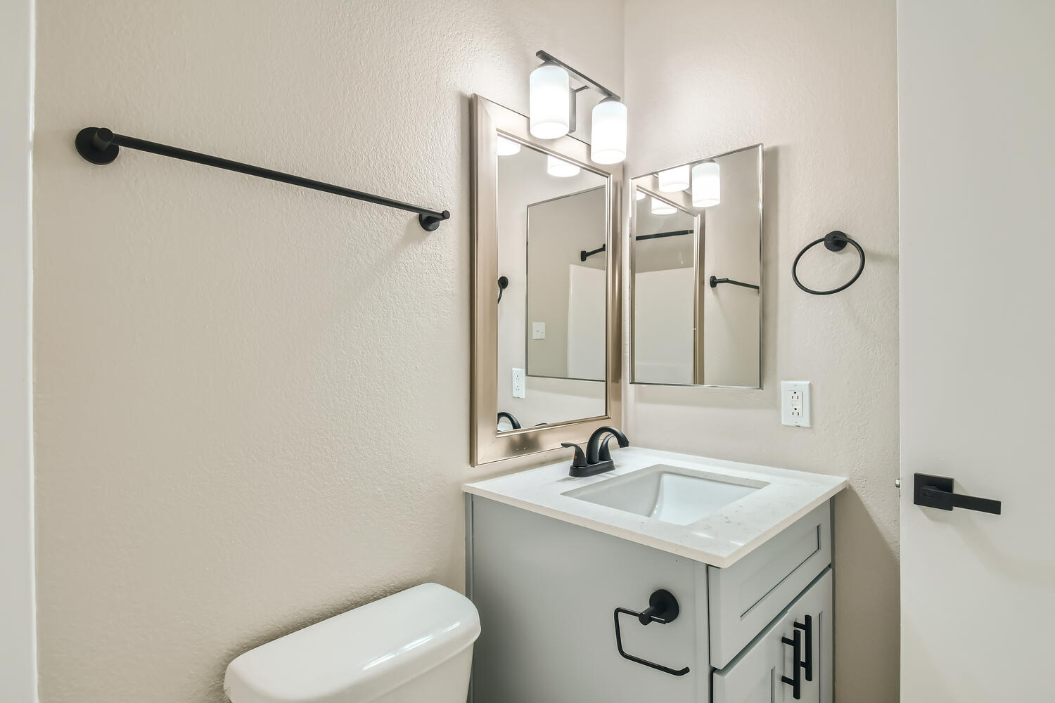 A remodeled bathroom at Rise on McClintock with a quartz countertop on the vanity and towel rods.
