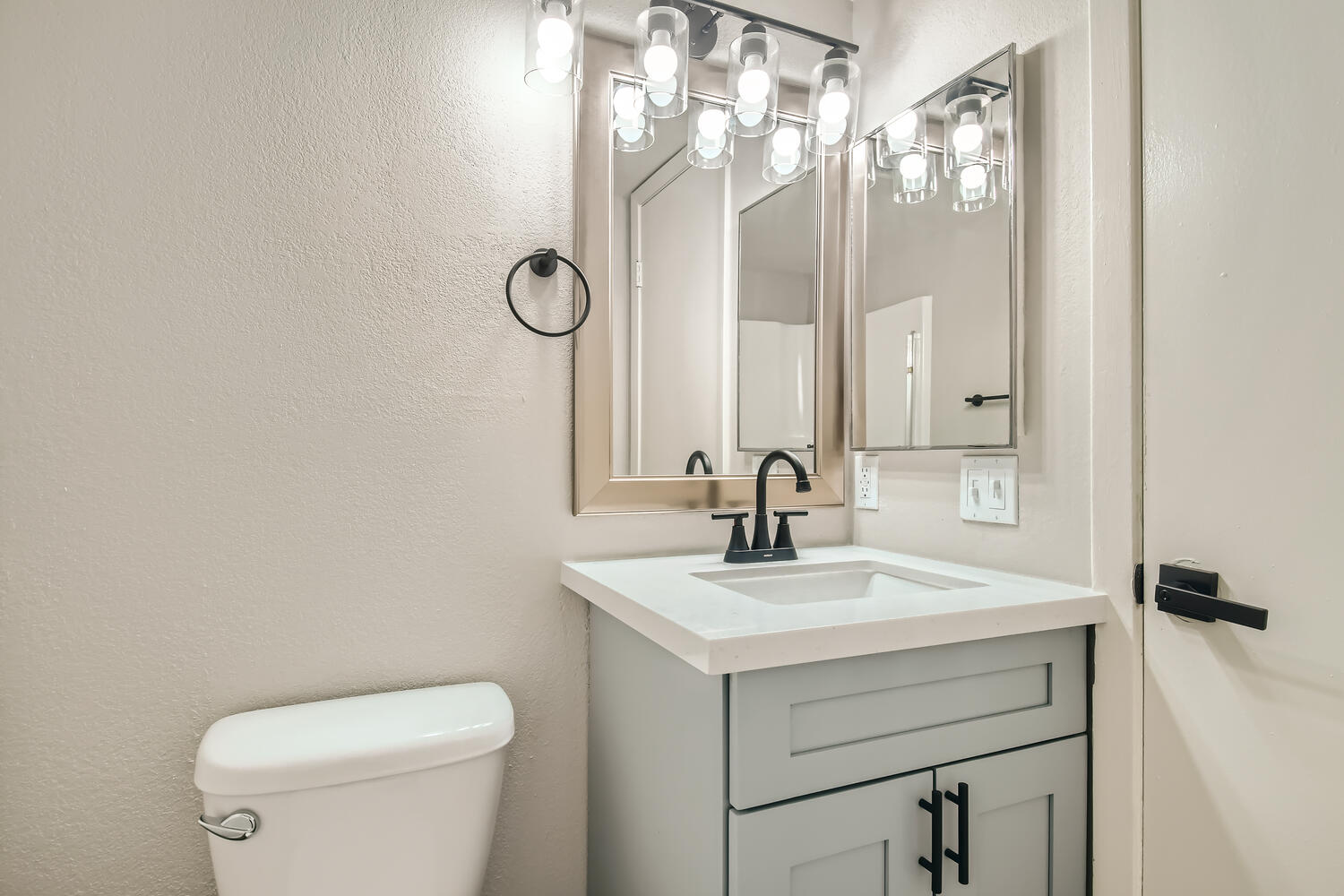 A remodeled bathroom at Rise on McClintock with a small quartz countertop vanity.