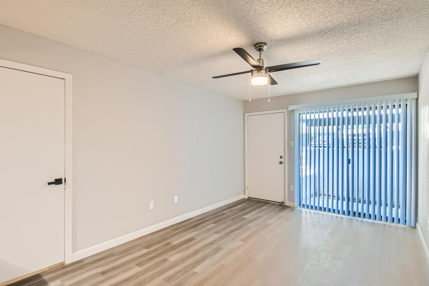 An open concept living area with a sliding door to the patio at Rise on McClintock.