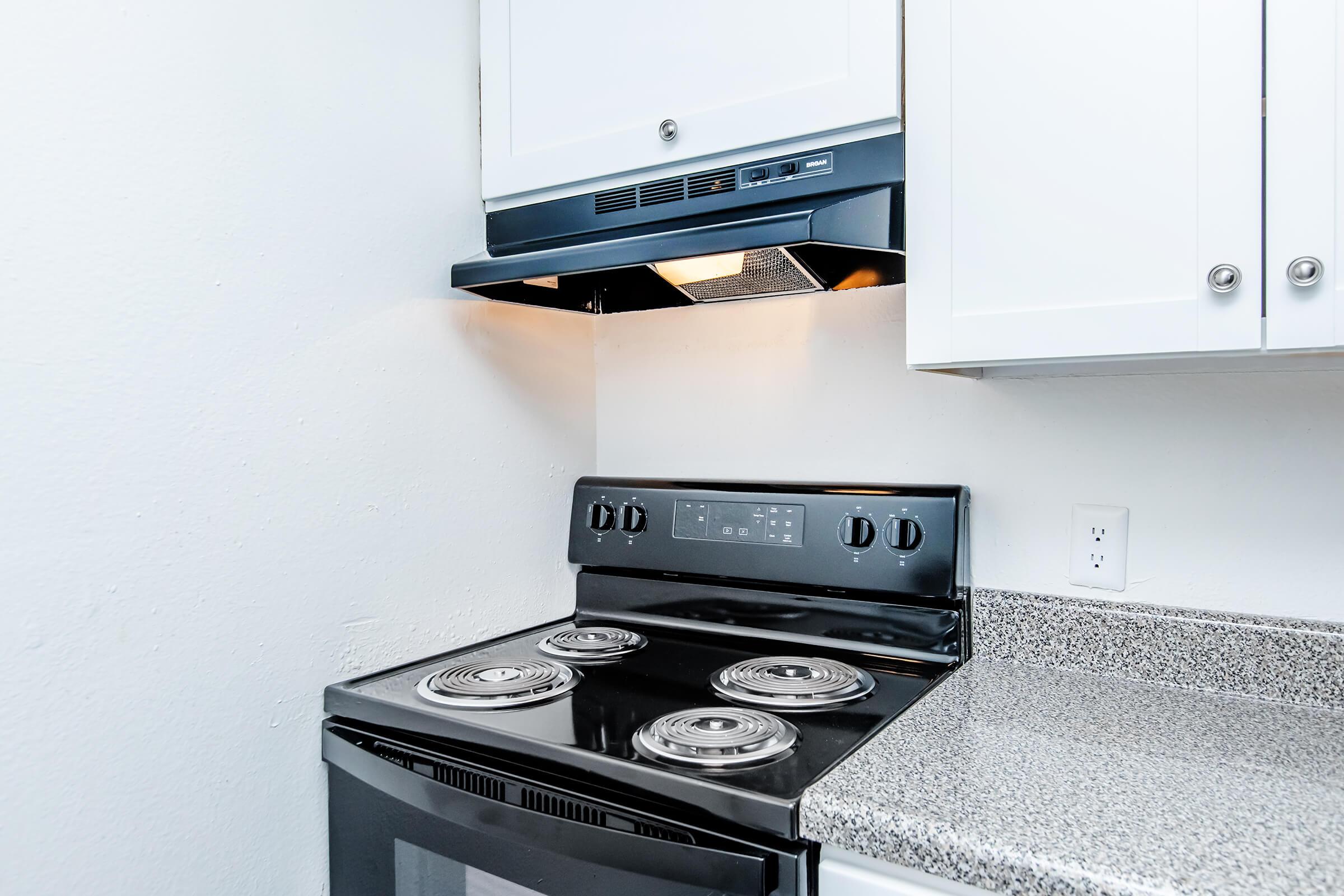 a stove top oven sitting inside of a kitchen