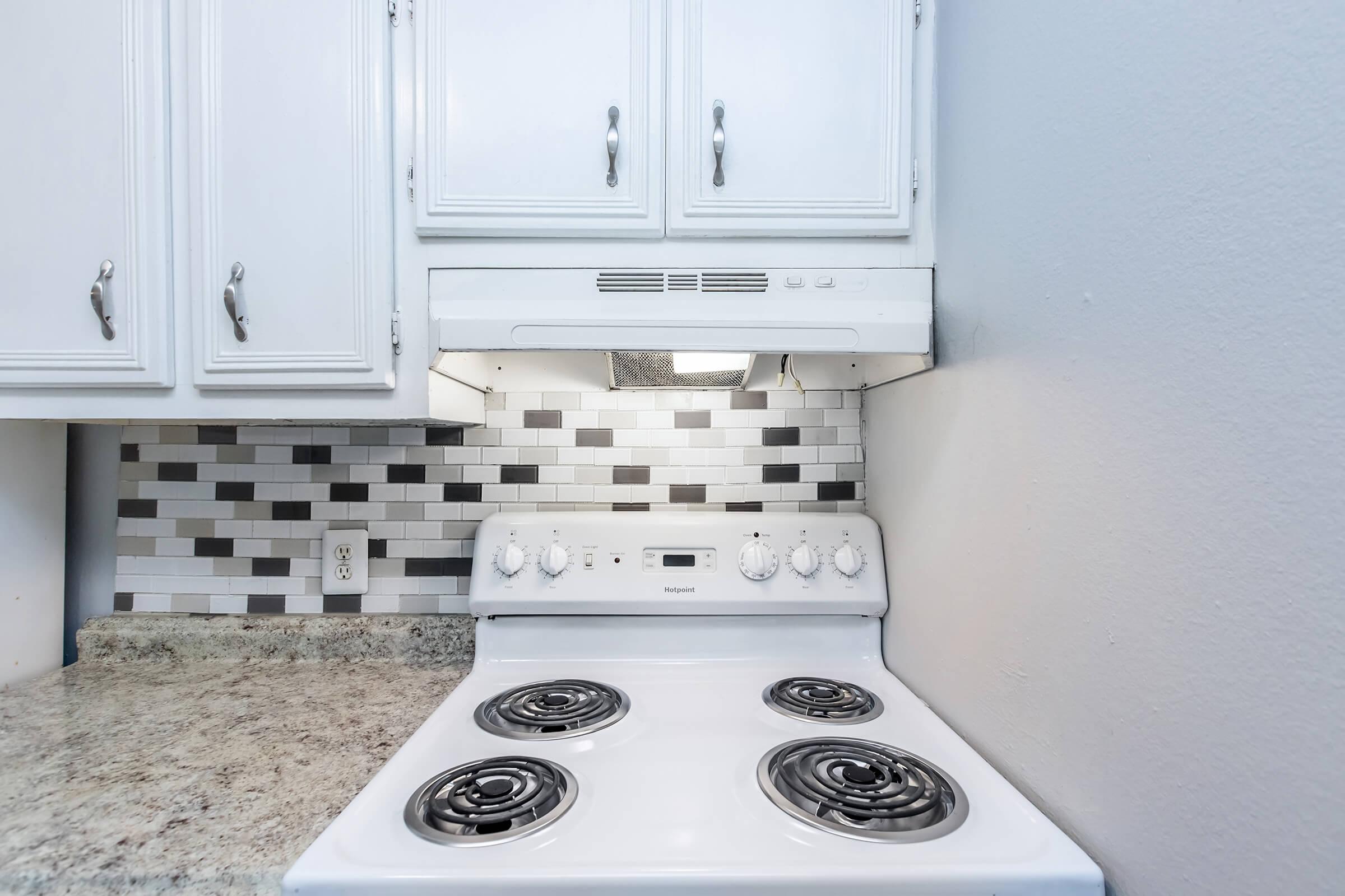 a stove top oven sitting inside of a kitchen