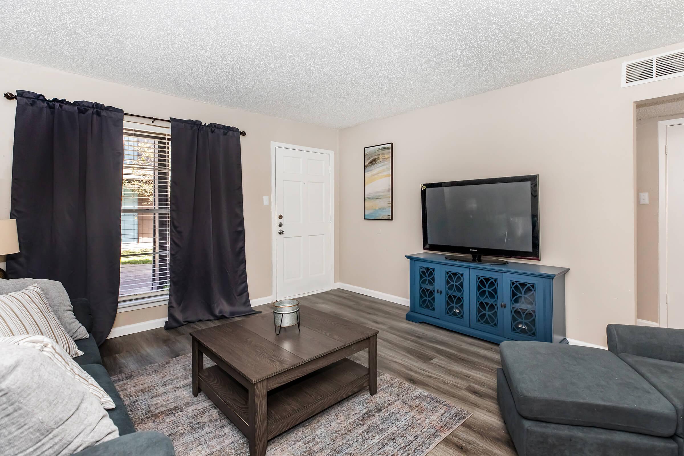 a living room filled with furniture and a flat screen tv