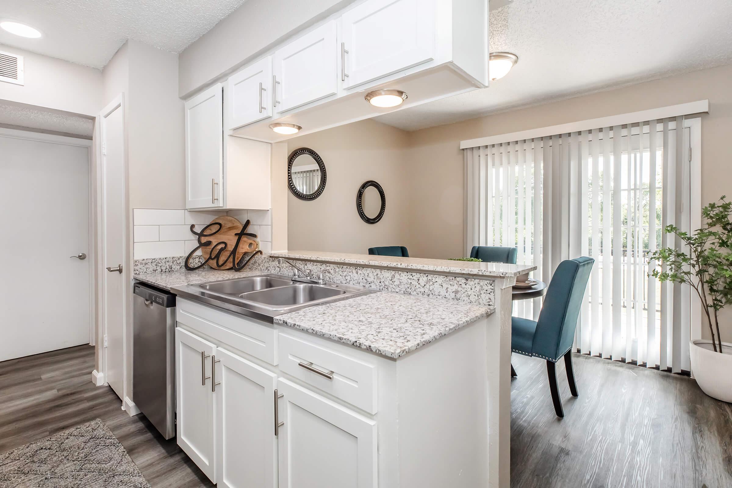 a kitchen with a sink and a mirror in a room