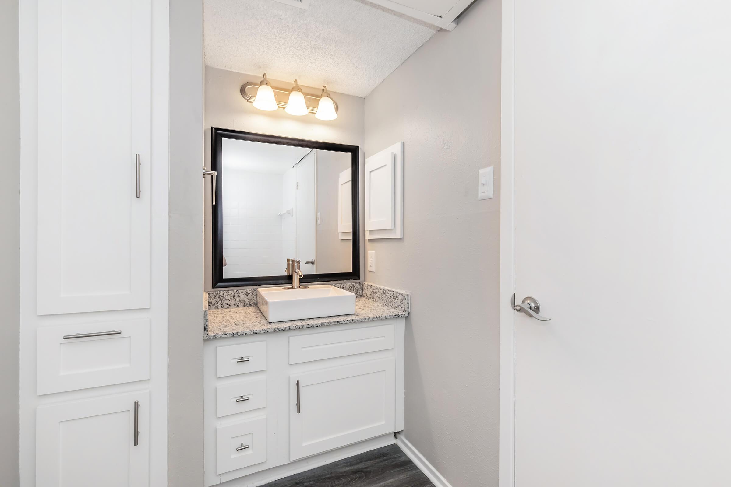 a kitchen with a sink and a mirror