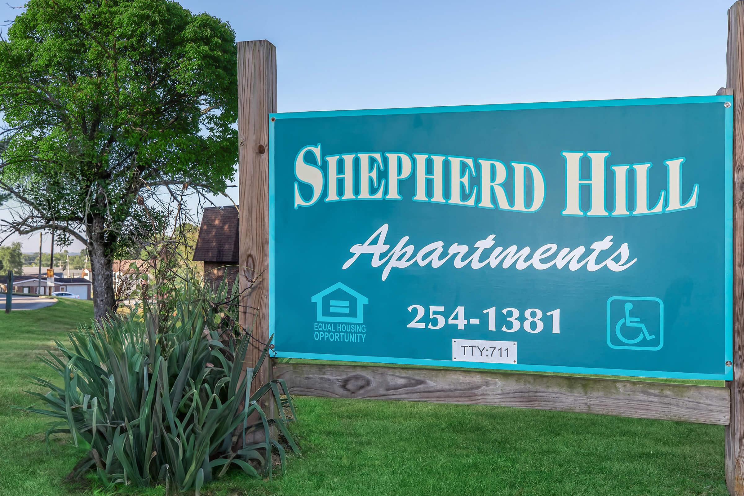 a sign in front of a green field