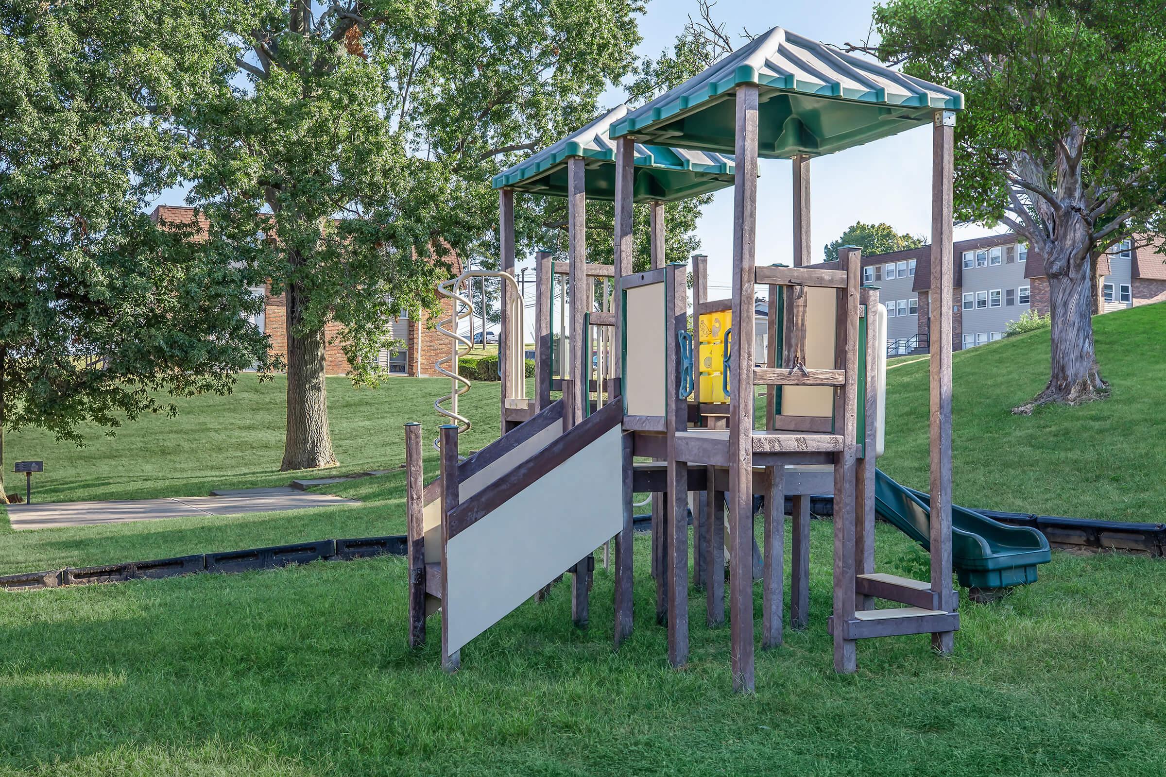 a couple of lawn chairs sitting on top of a grass covered park