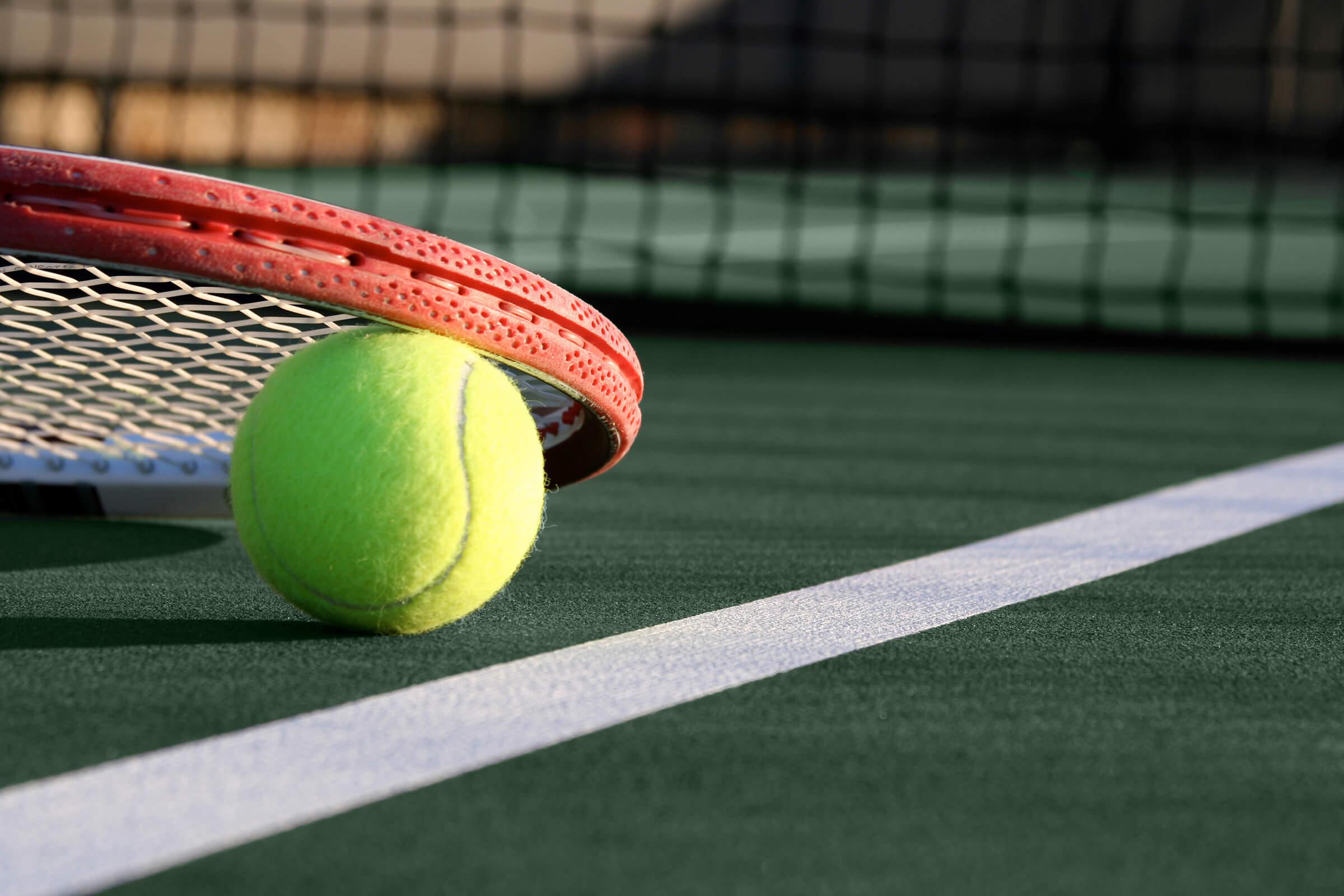a green ball on a court with a racket