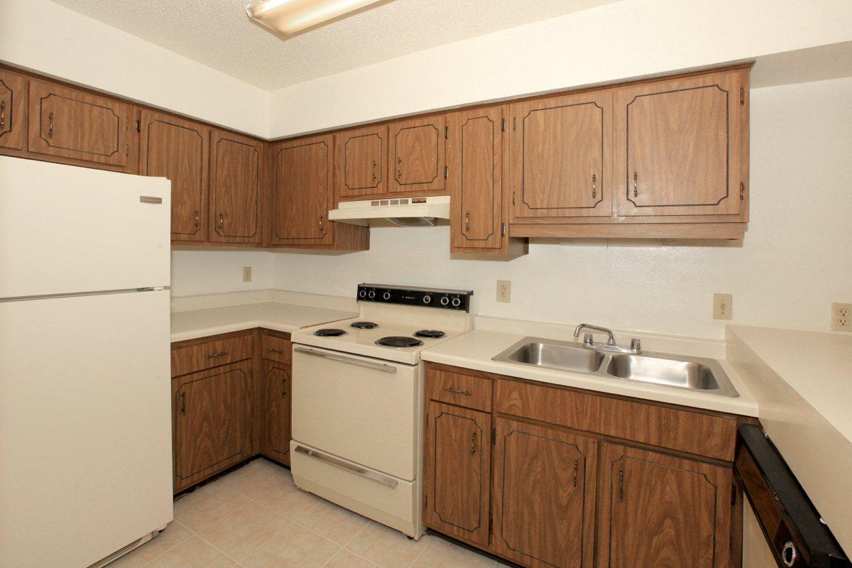 a kitchen with white appliances and wooden cabinets