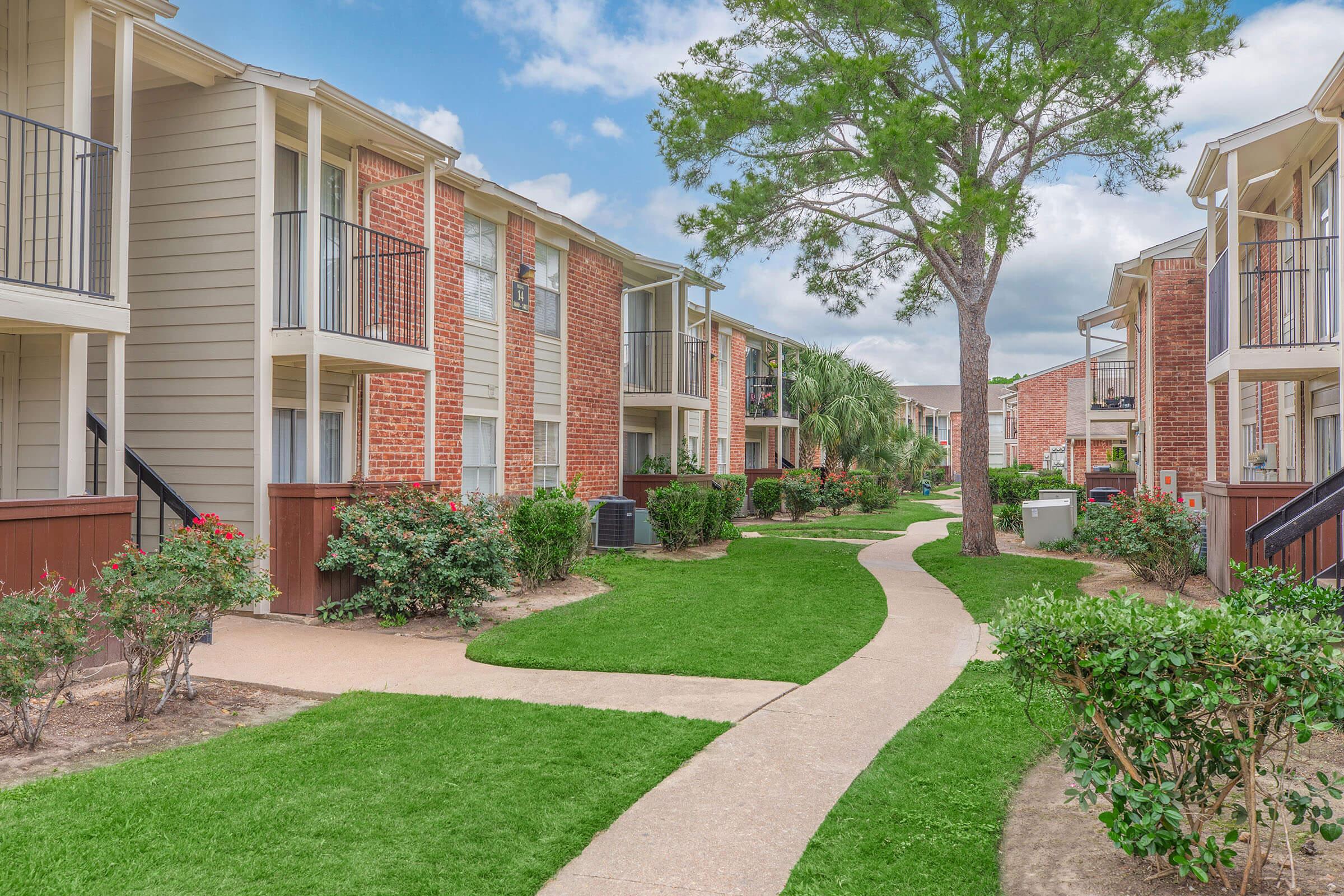 a large lawn in front of a brick building