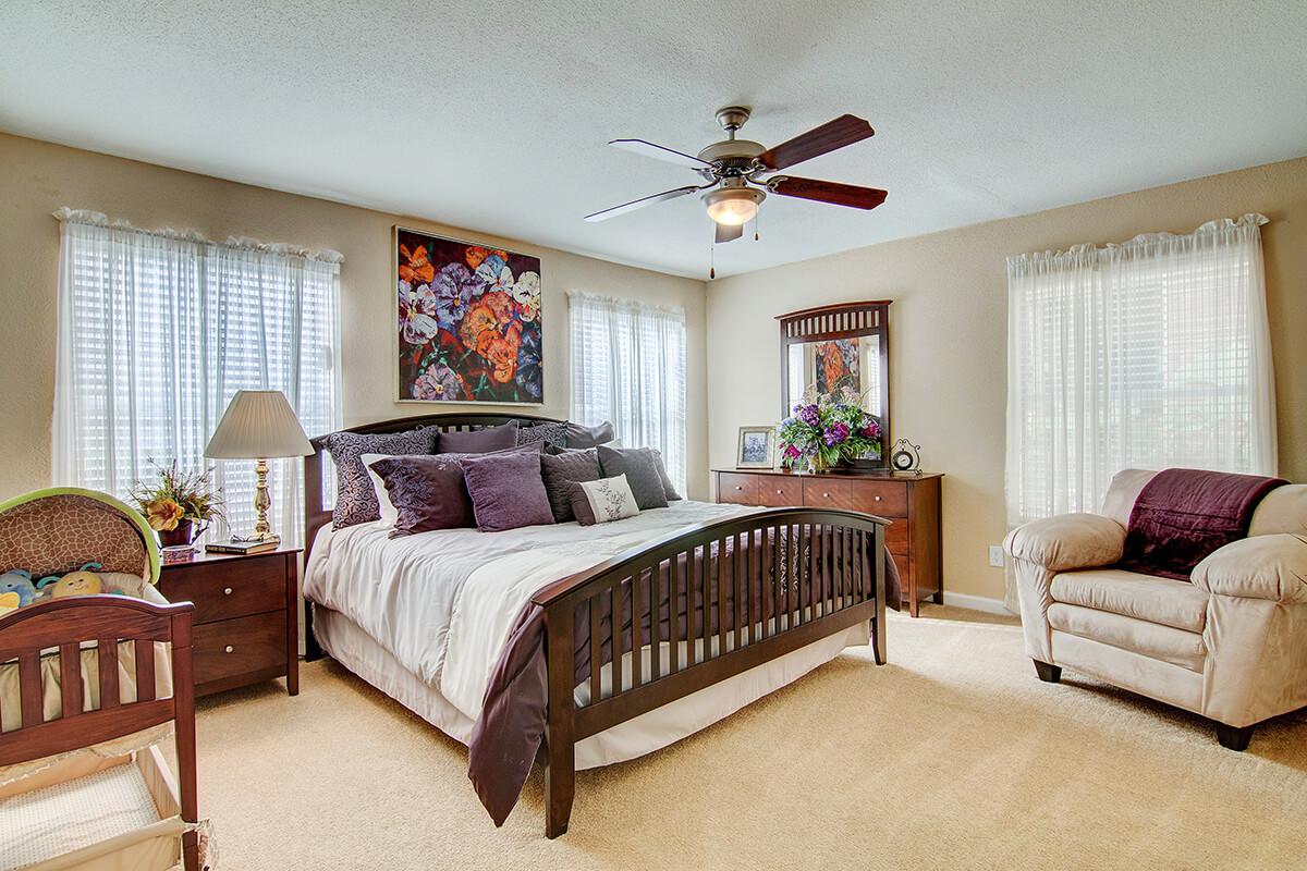 a living room filled with furniture and a bed in a bedroom