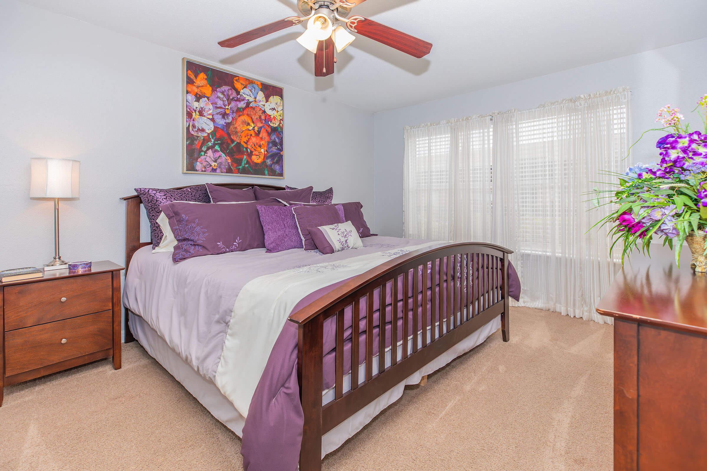 a bedroom with a bed and desk in a room