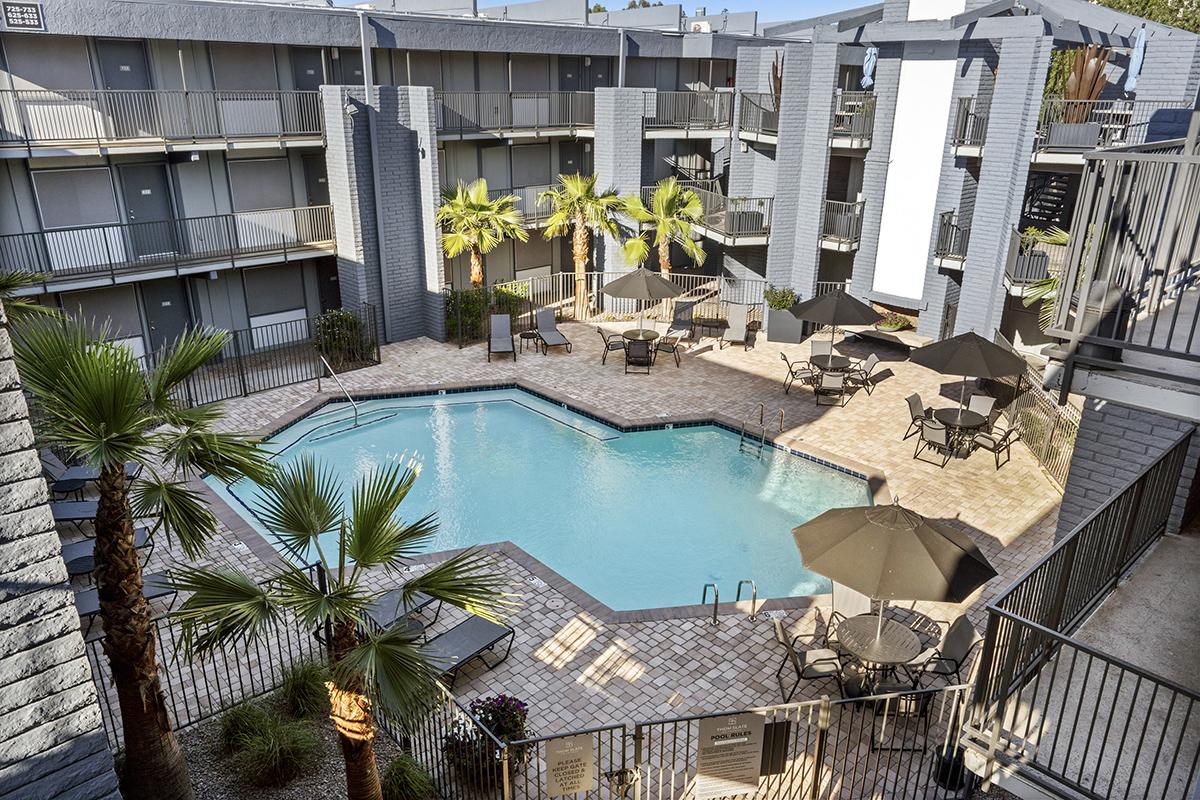 a building with a pool in front of a fence