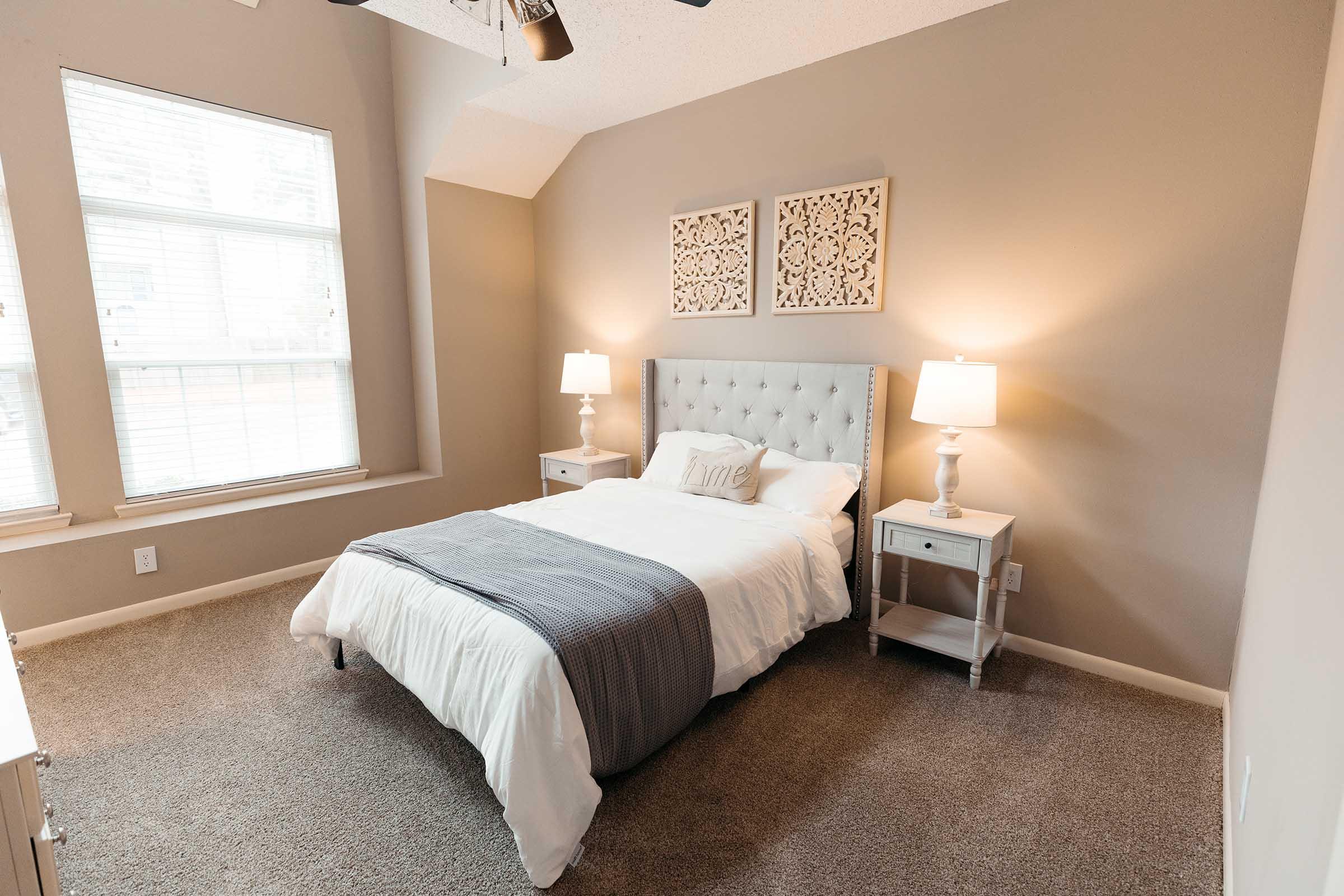 a bedroom with a bed and desk in a hotel room