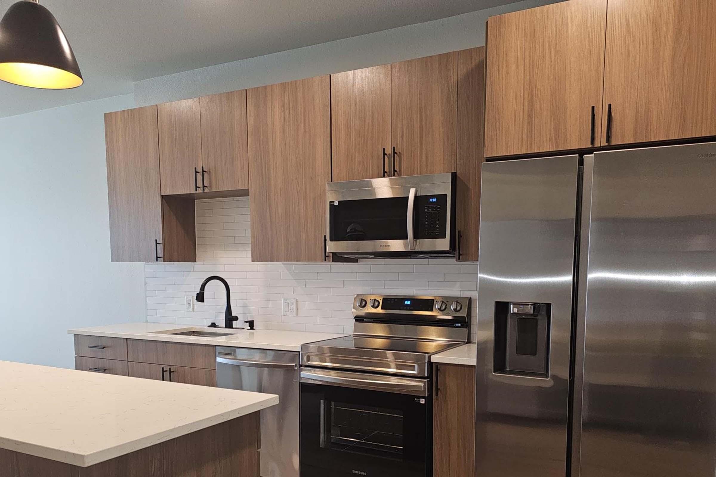 a kitchen with stainless steel appliances and wooden cabinets