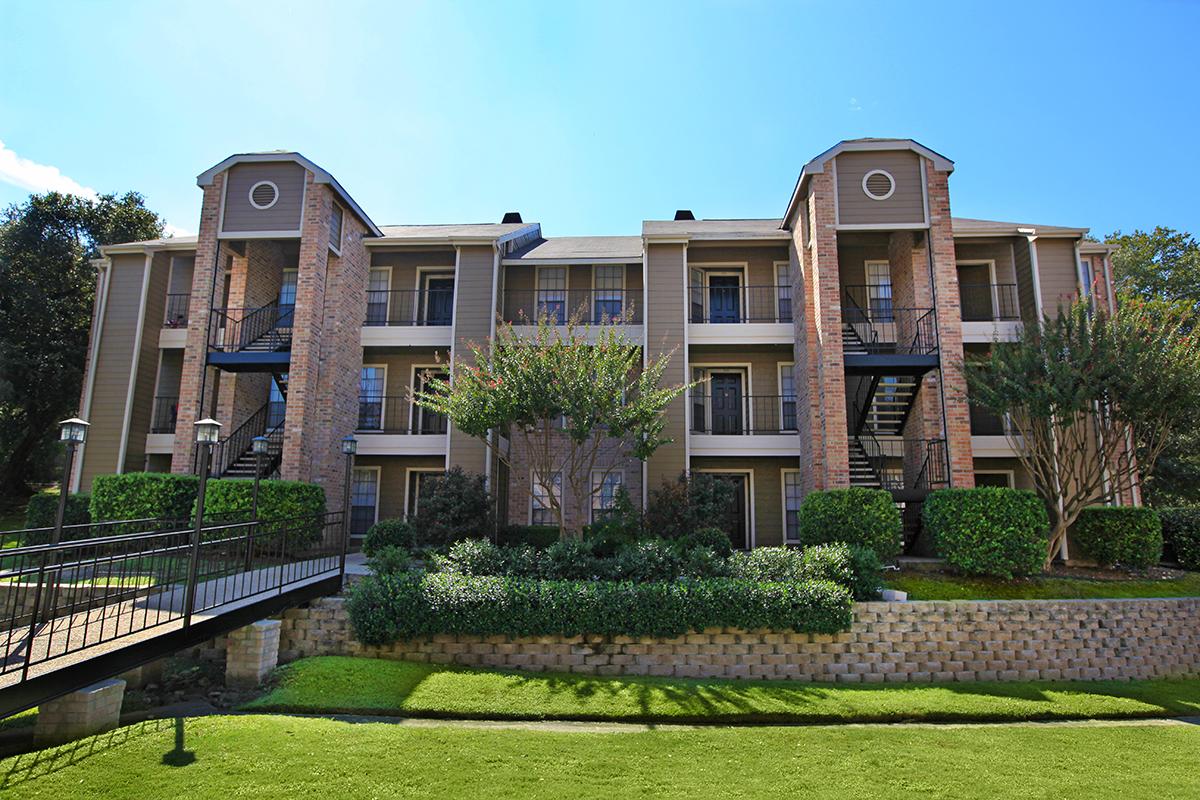 a large brick building with grass in front of a house