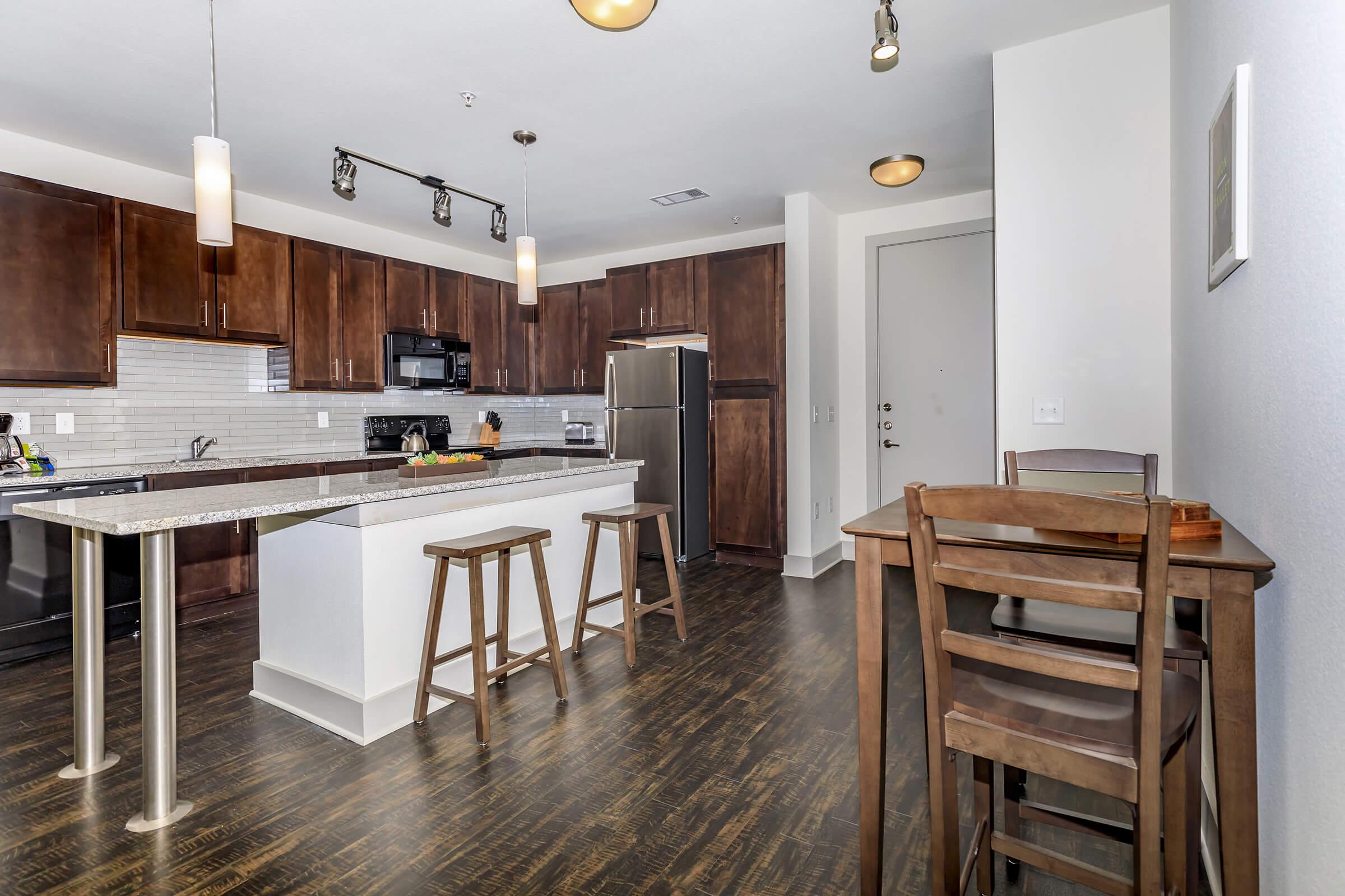 a kitchen with wooden cabinets and a dining room table