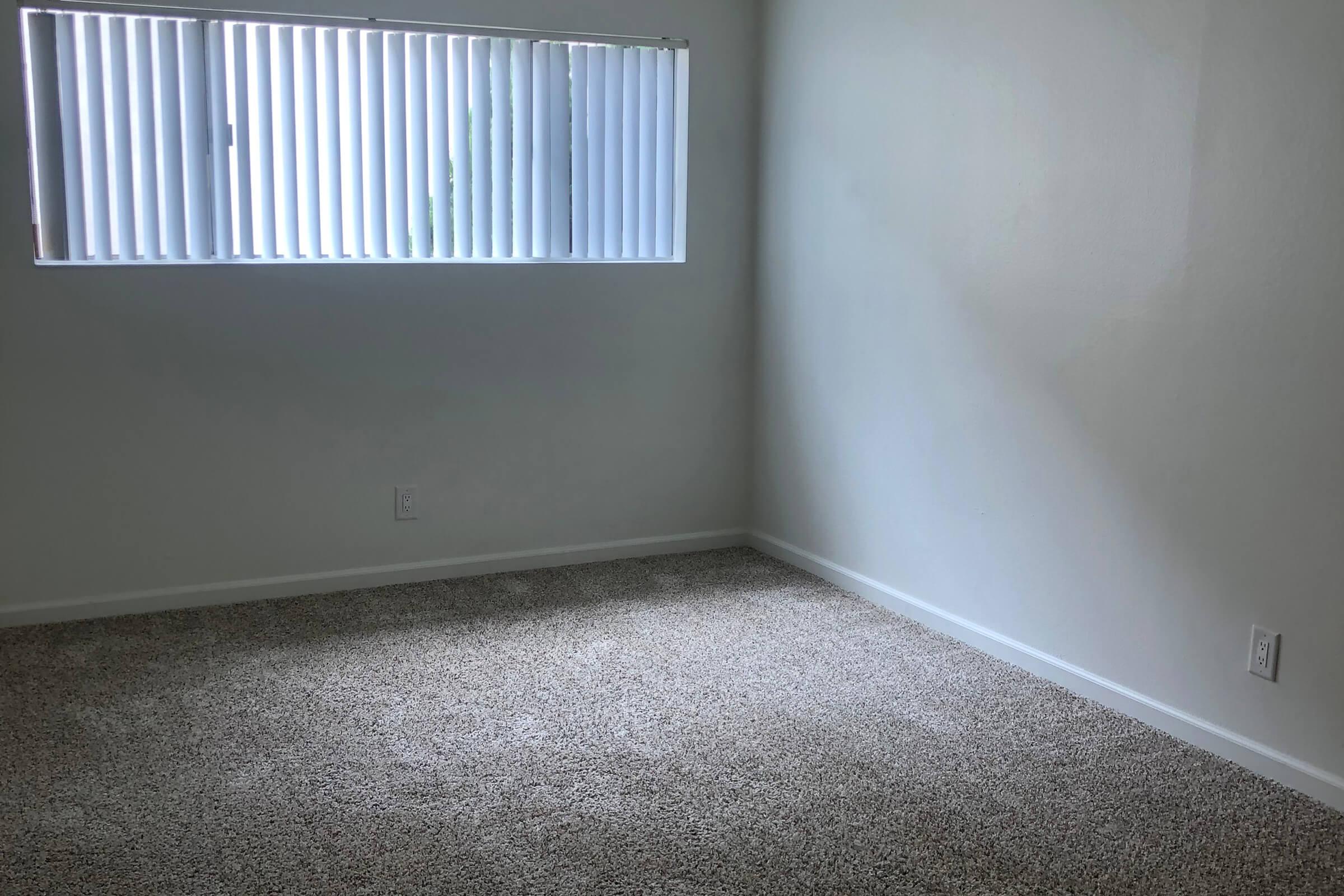 Vacant bedroom with carpeted floors