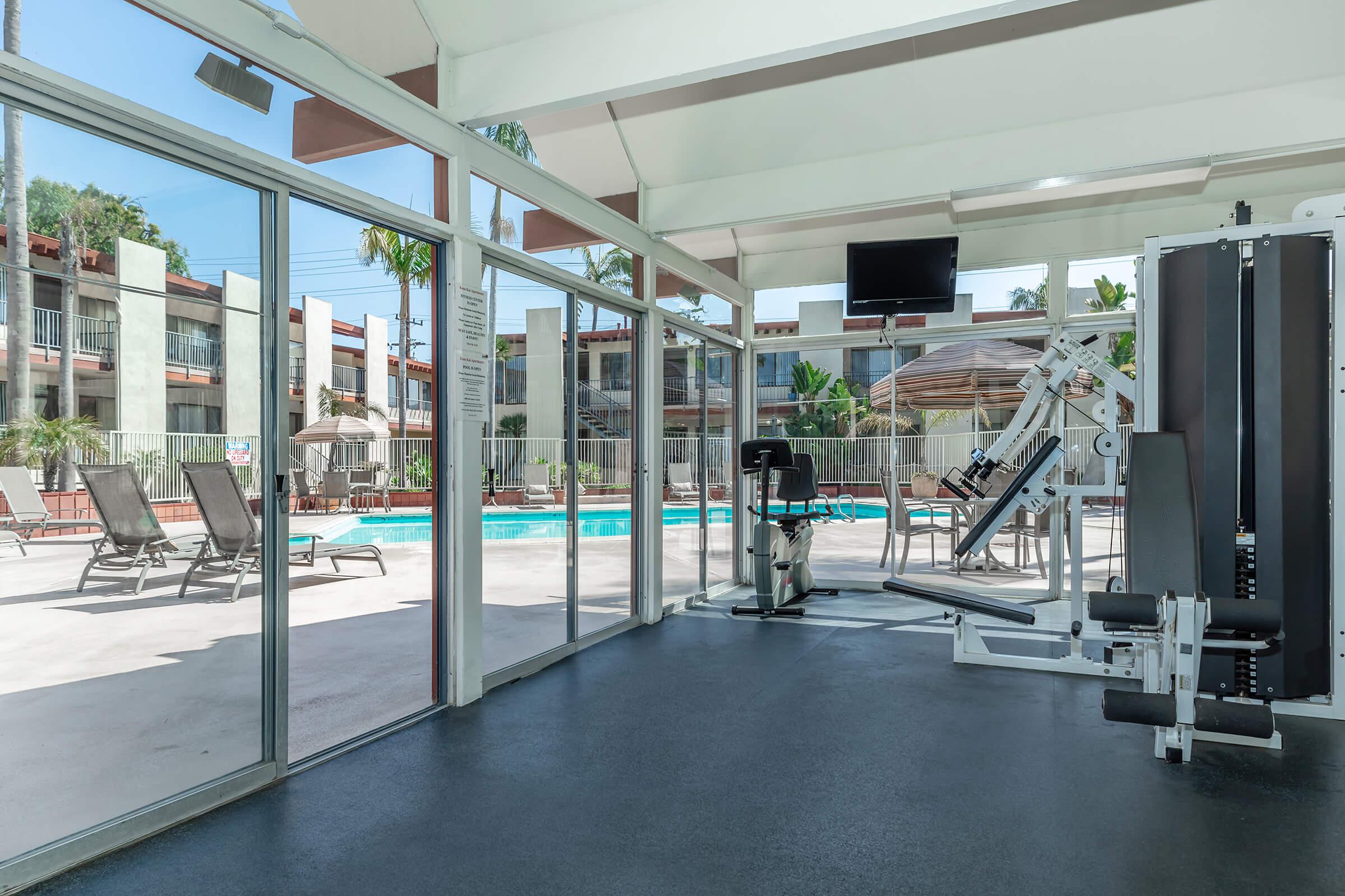 Kona Kai Apartments community gym with glass windows to the community pool