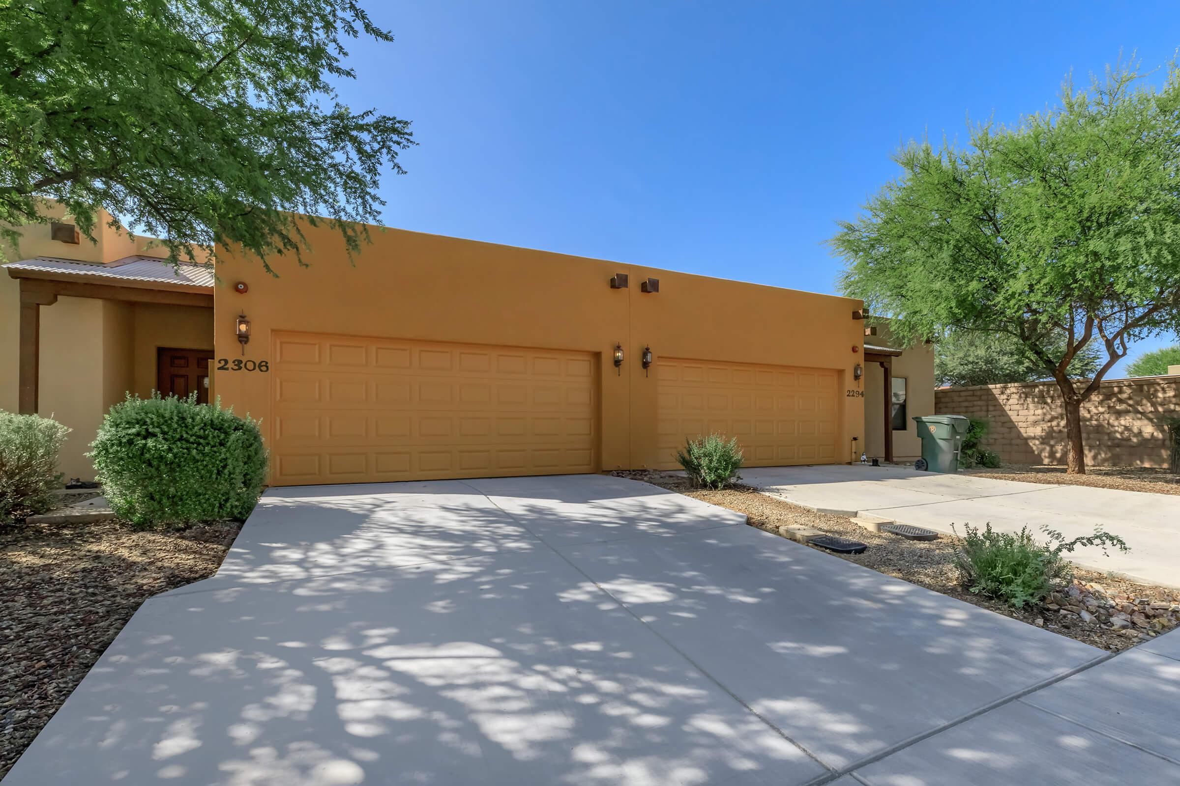 a house with bushes in front of a brick building