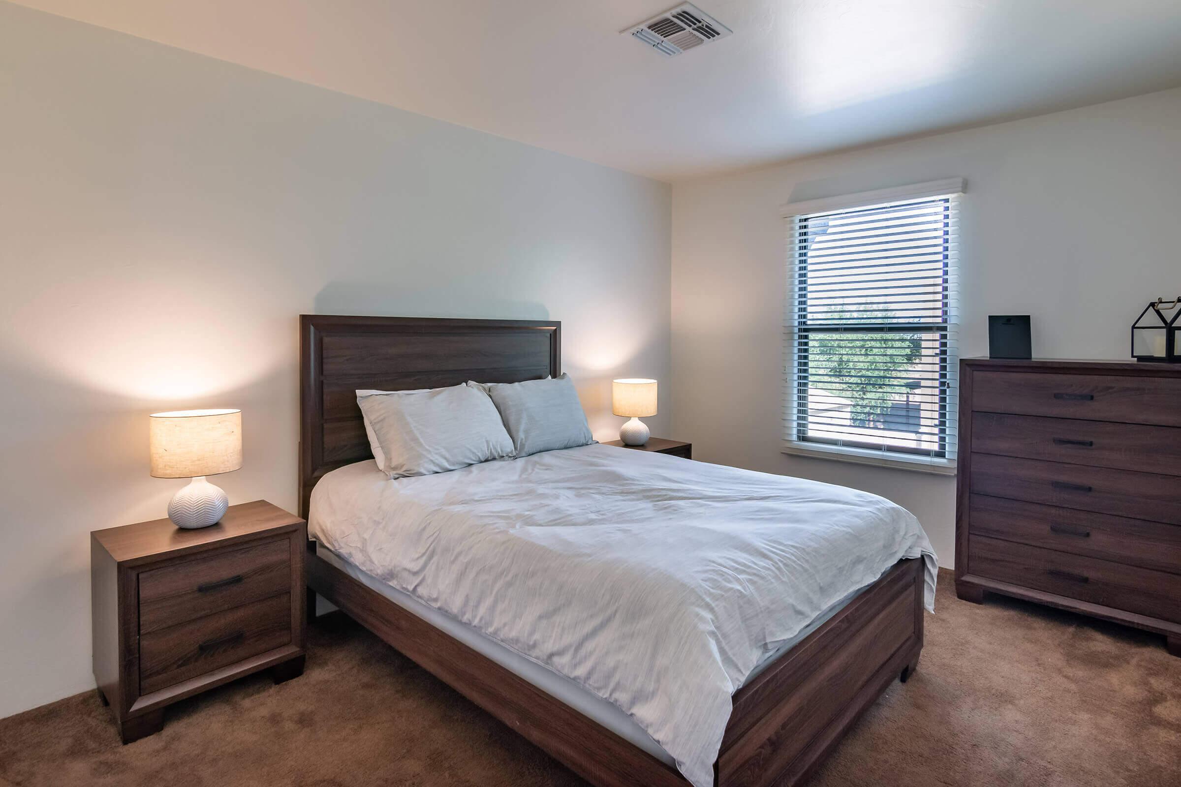 a bedroom with a bed and desk in a room