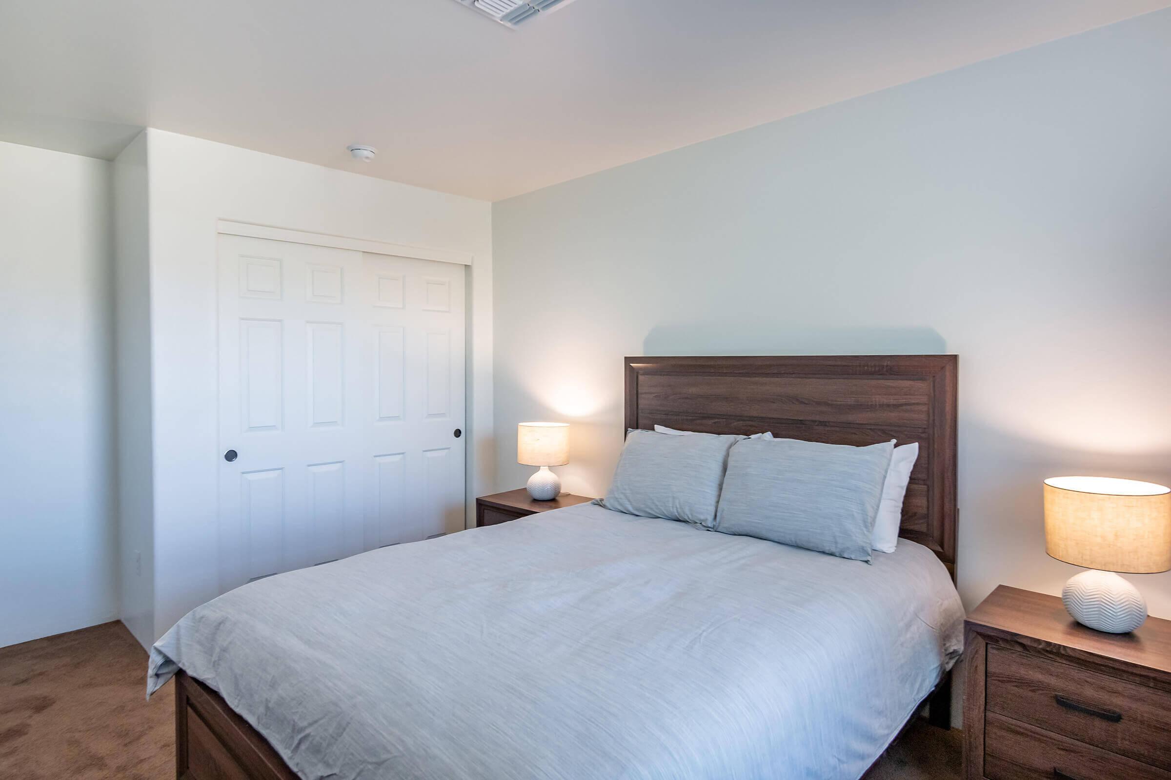 a bedroom with a bed and desk in a hotel room