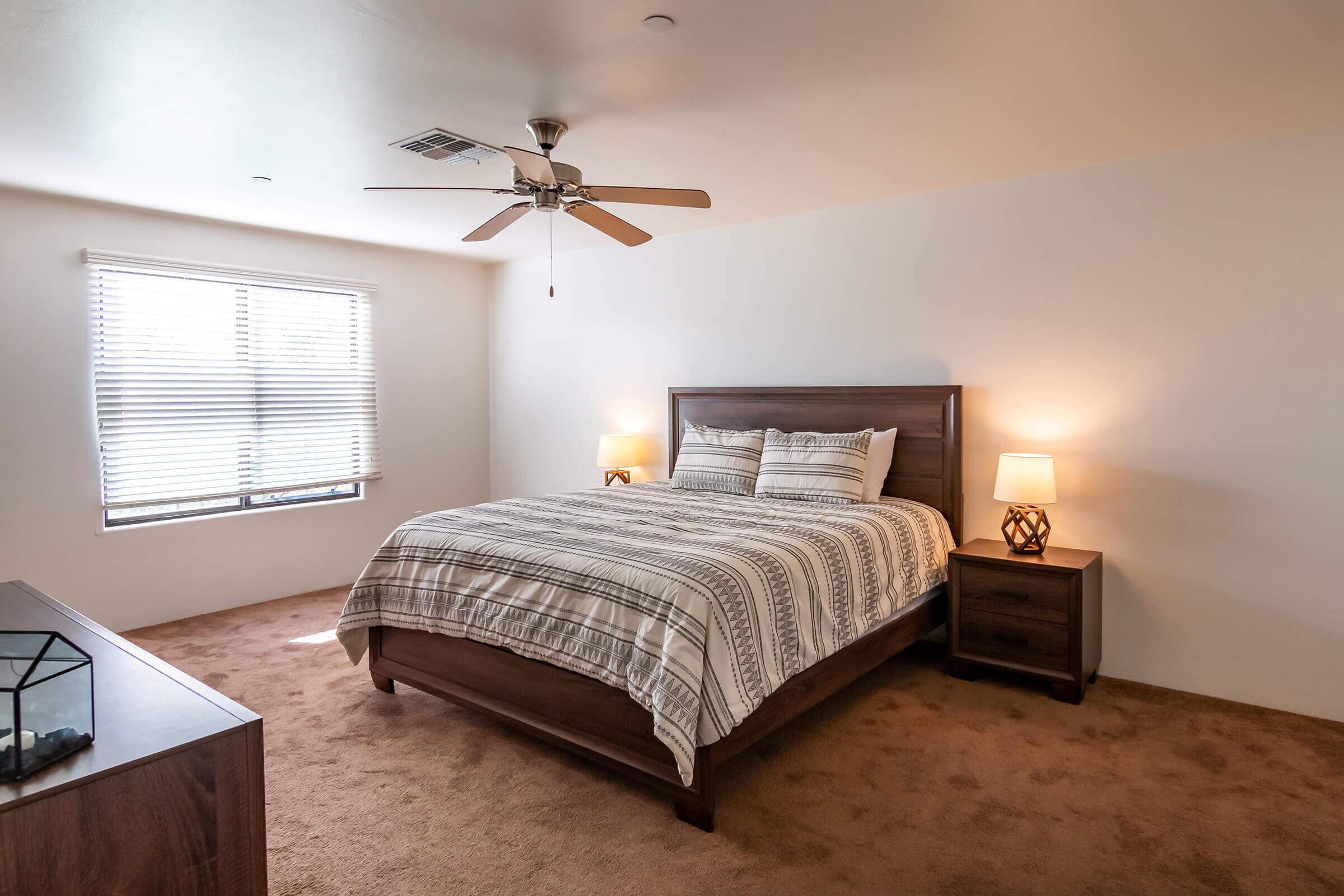 a bedroom with a bed and desk in a room