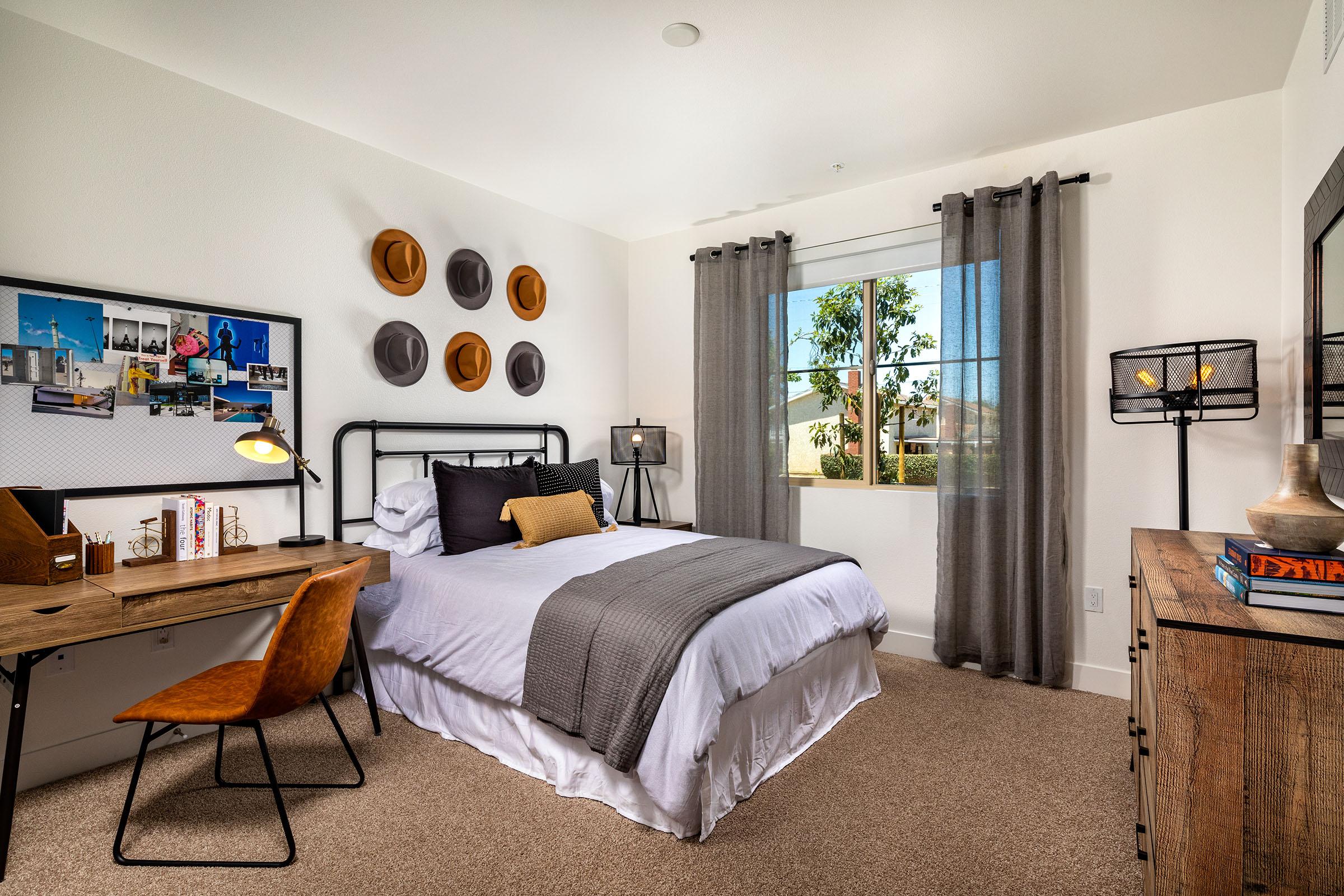 a bedroom with a bed and desk in a hotel room