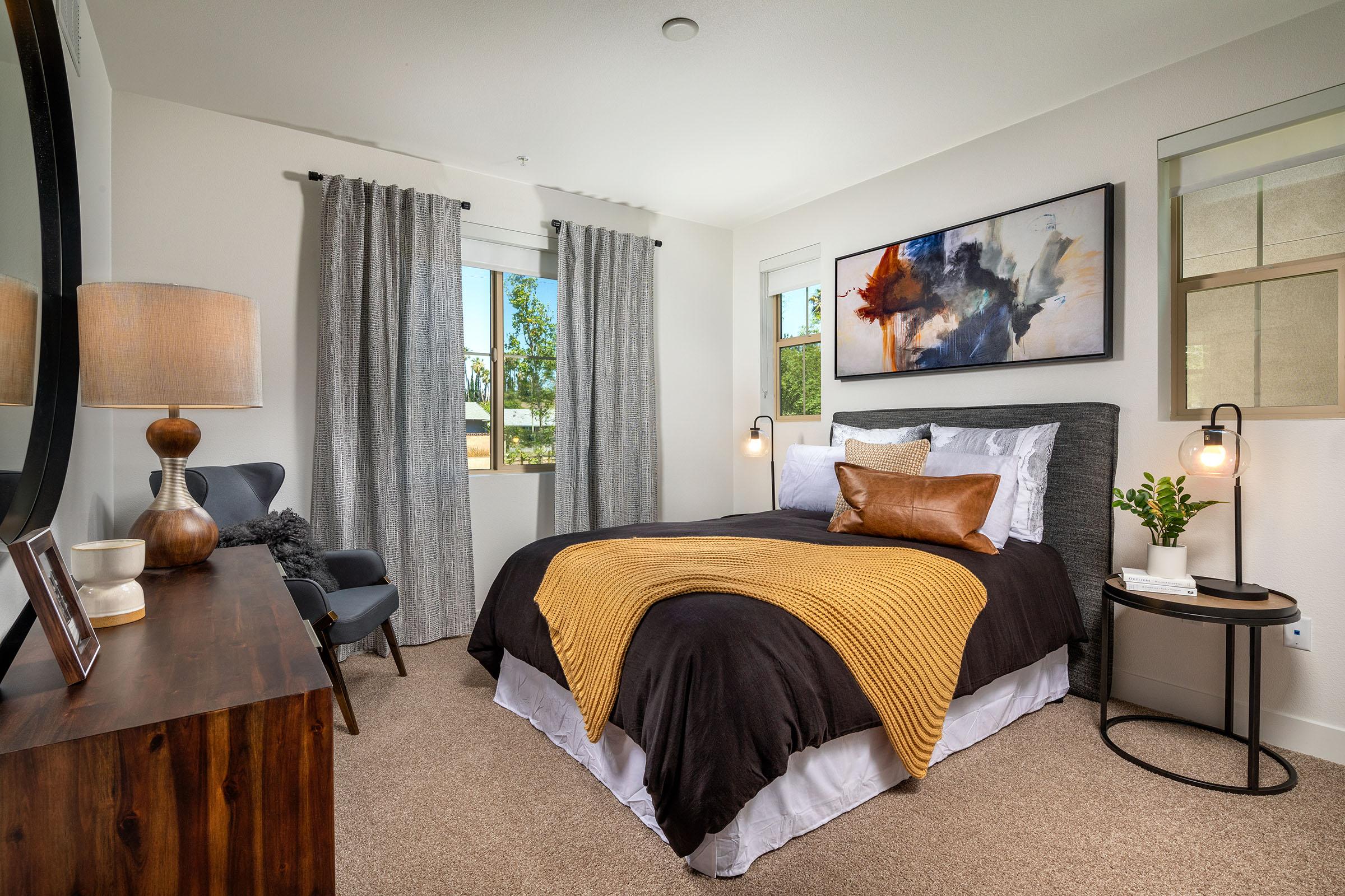 a bedroom with a bed and a chair in a living room