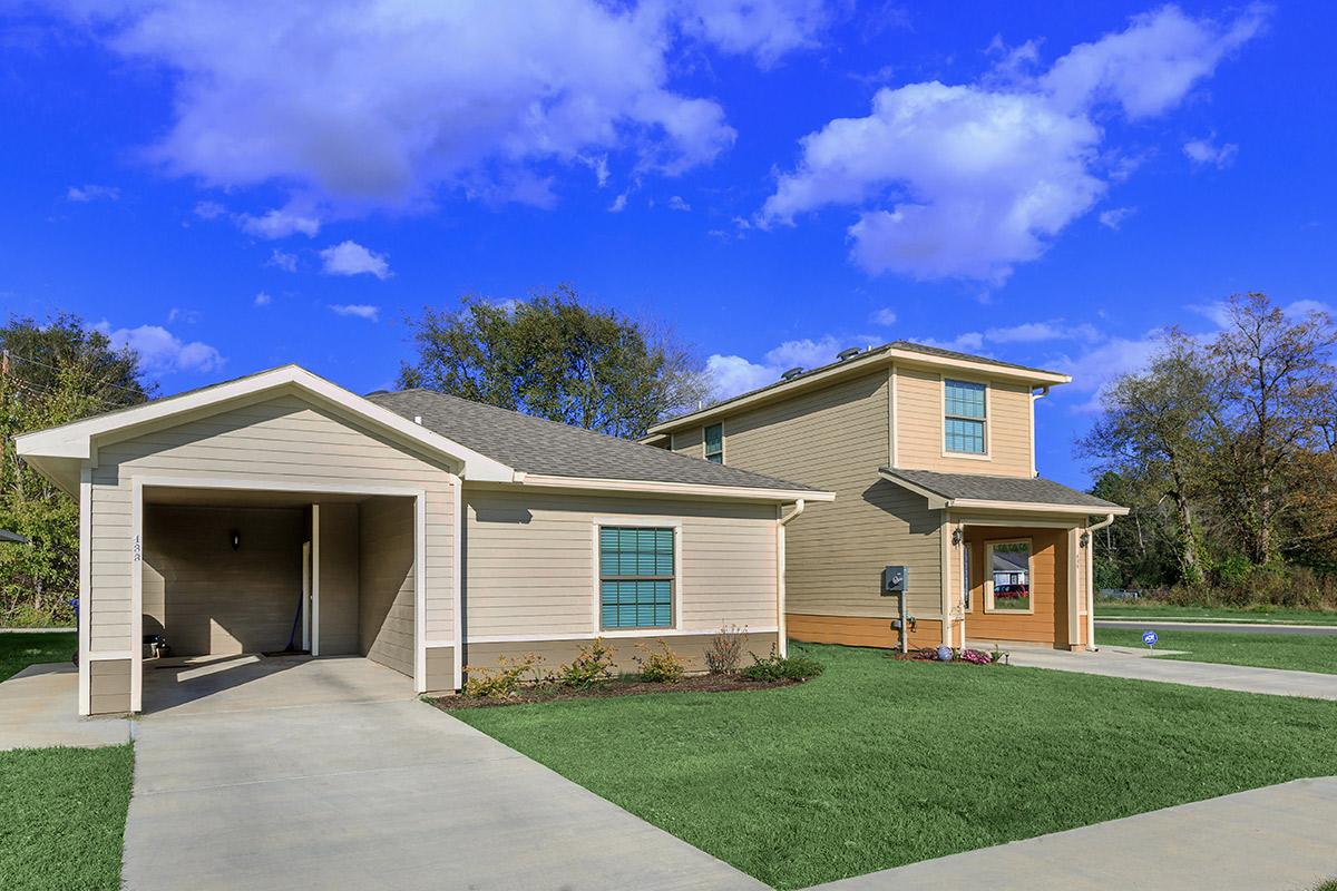 a large brick building with grass in front of a house