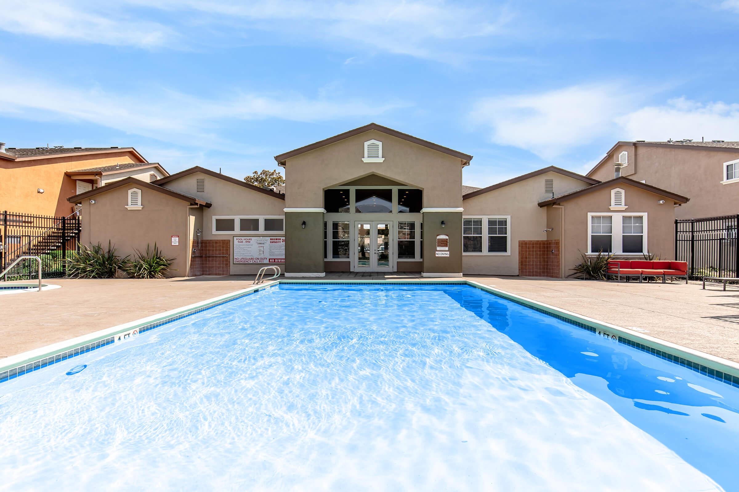 a house with a pool in front of a building