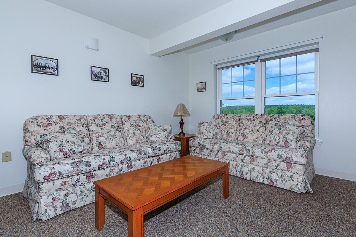 a living room with a bed and a window