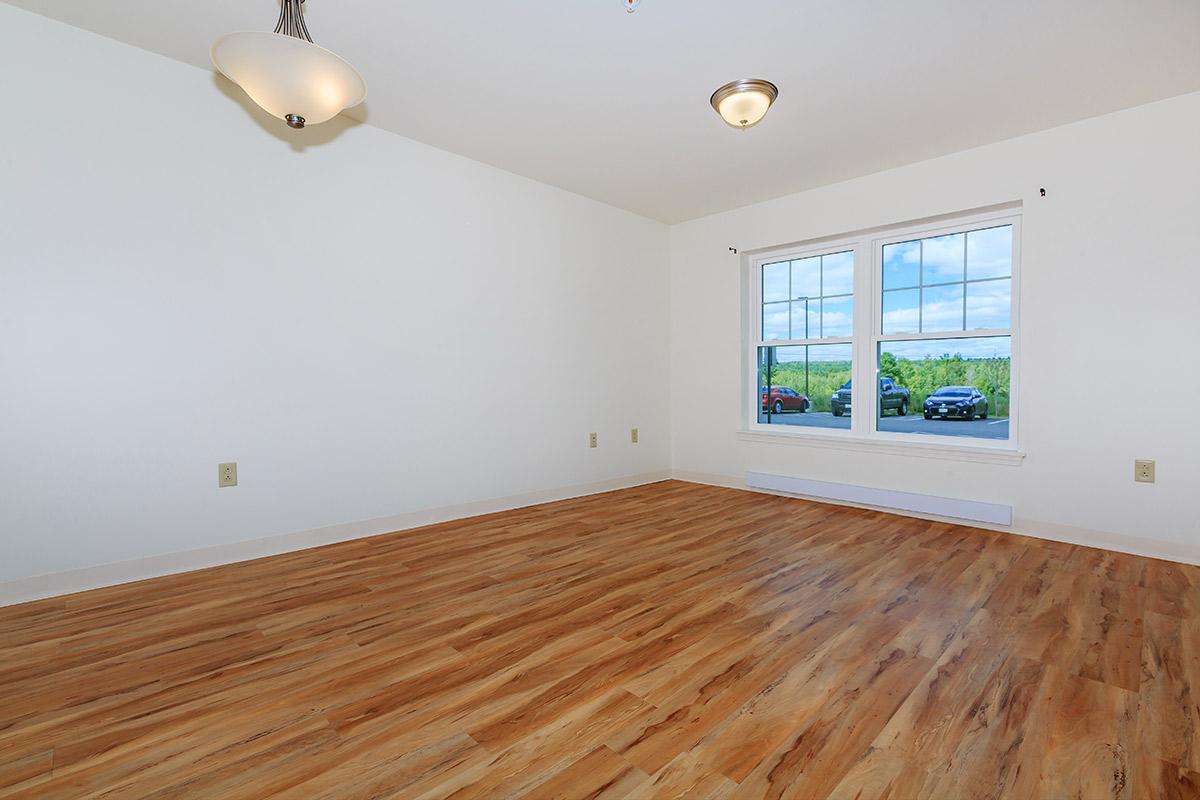 a bedroom with a wood floor