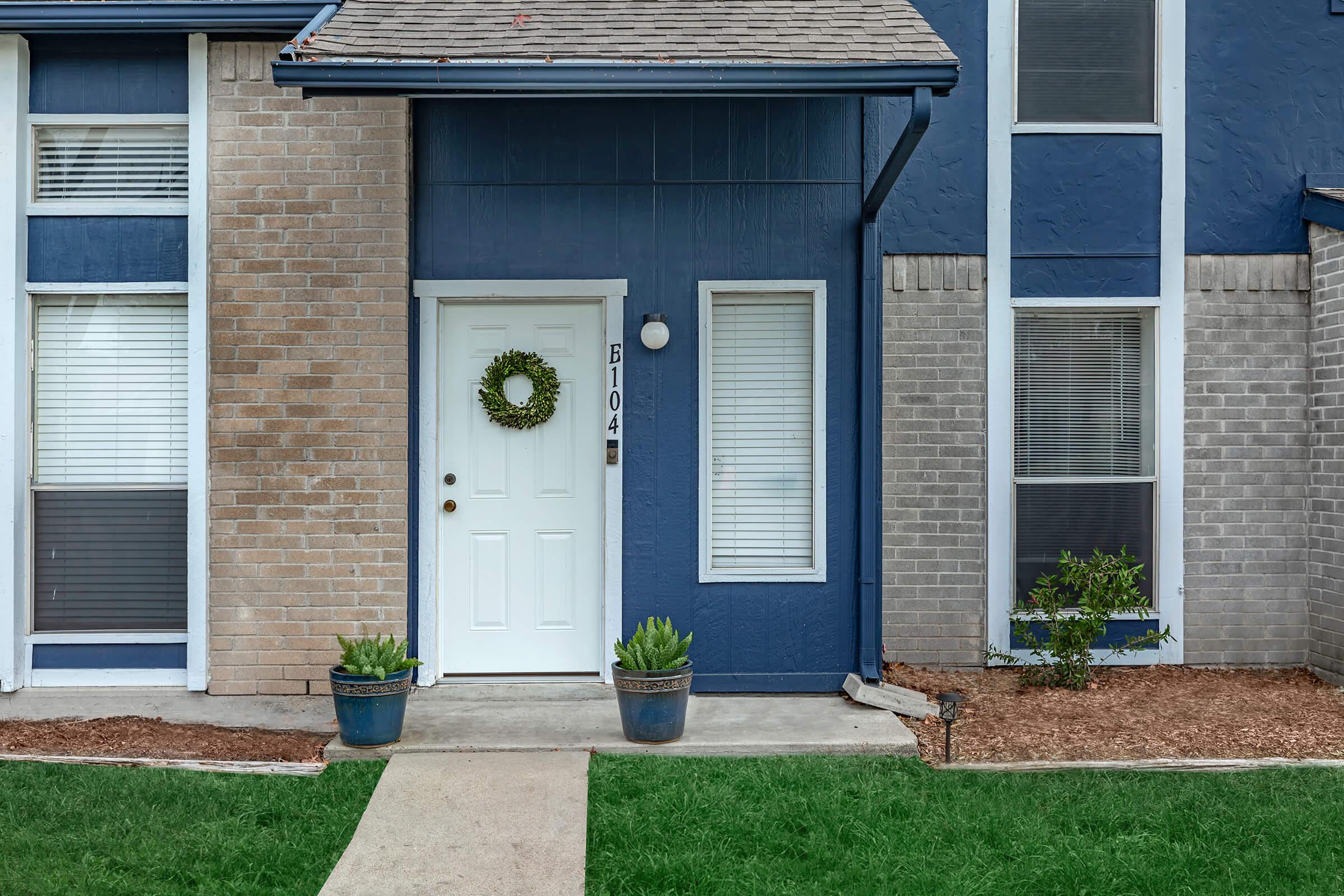 a house with a lawn in front of a brick building