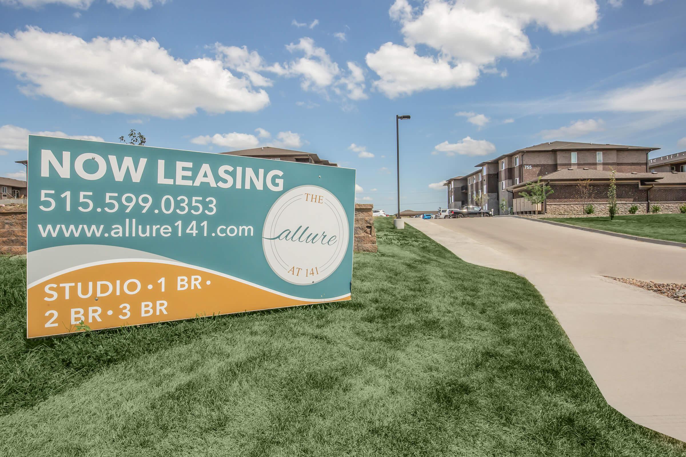 a sign on the side of a grass covered field