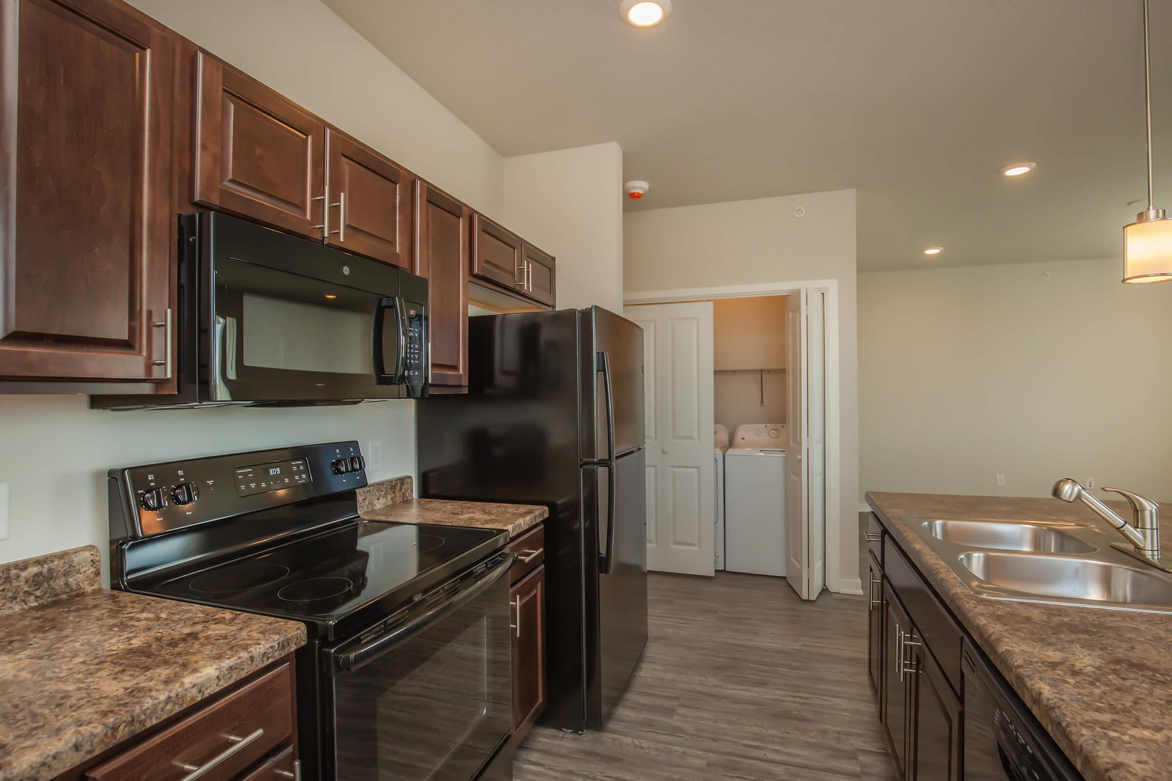 a modern kitchen with stainless steel appliances and wooden cabinets